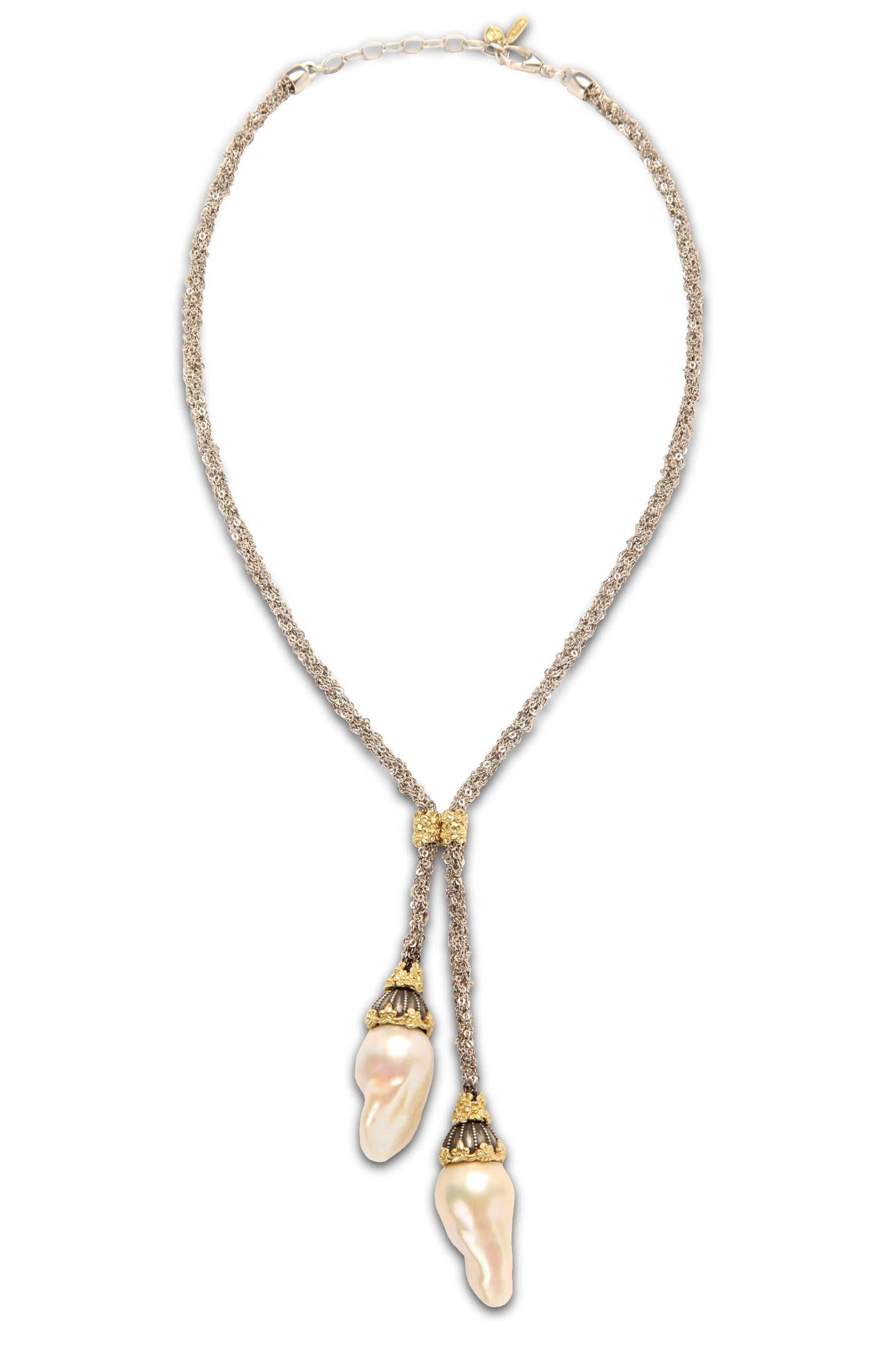 Silver and 18K Gold Lariat Necklace with Two Baroque Pearl Drops by Stambolian

This unique necklaces features a gorgeous mesh type chain that is connected in the center by a gold floral design

The design leads to two drops with fresh water baroque