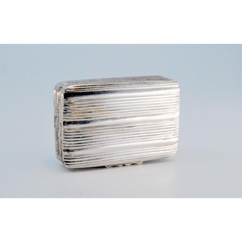 Beschreibung: Vinaigrette-Dose aus Silber und Gold mit Friesen aus der Zeit von Georg IV. Metall: Silber - Gold. Herkunft: Englisch. Marke: Birmingham. Gewicht: 14,82 Gramm. Abmessungen: 3.3x0.8cm. Inhalt: (Silber)925/1000- (Gold)375/1000.