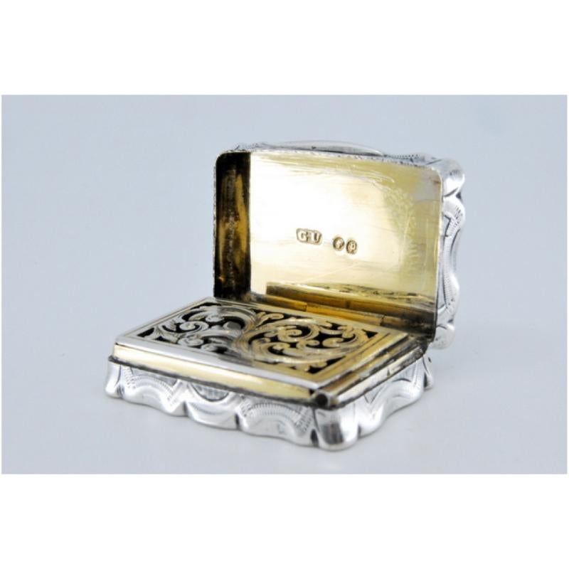Description: Silver and gold vinaigrette box with relief and shield on the lid. Metal: Silver - Gold. Origin: English. Brand: Birmingham. Weight: 18.67 grams. Dimensions: 3.5x0.9cm. Content: 925/1000 (Silver) - 375/1000 (Gold). Assay Mark: Yes.