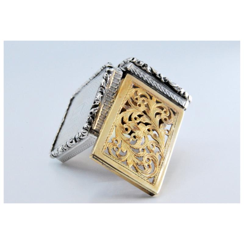 Description: Silver and gold vinaigrette box with Victorian period trim on the lid and casing. . Metal: Silver/Gold. Origin: English. Brand: Birmingham. Weight: 13.85 grams. Dimensions: 3.2x0.9cm. Content: (Silver)925/1000-(Gold)375/1000. Assay