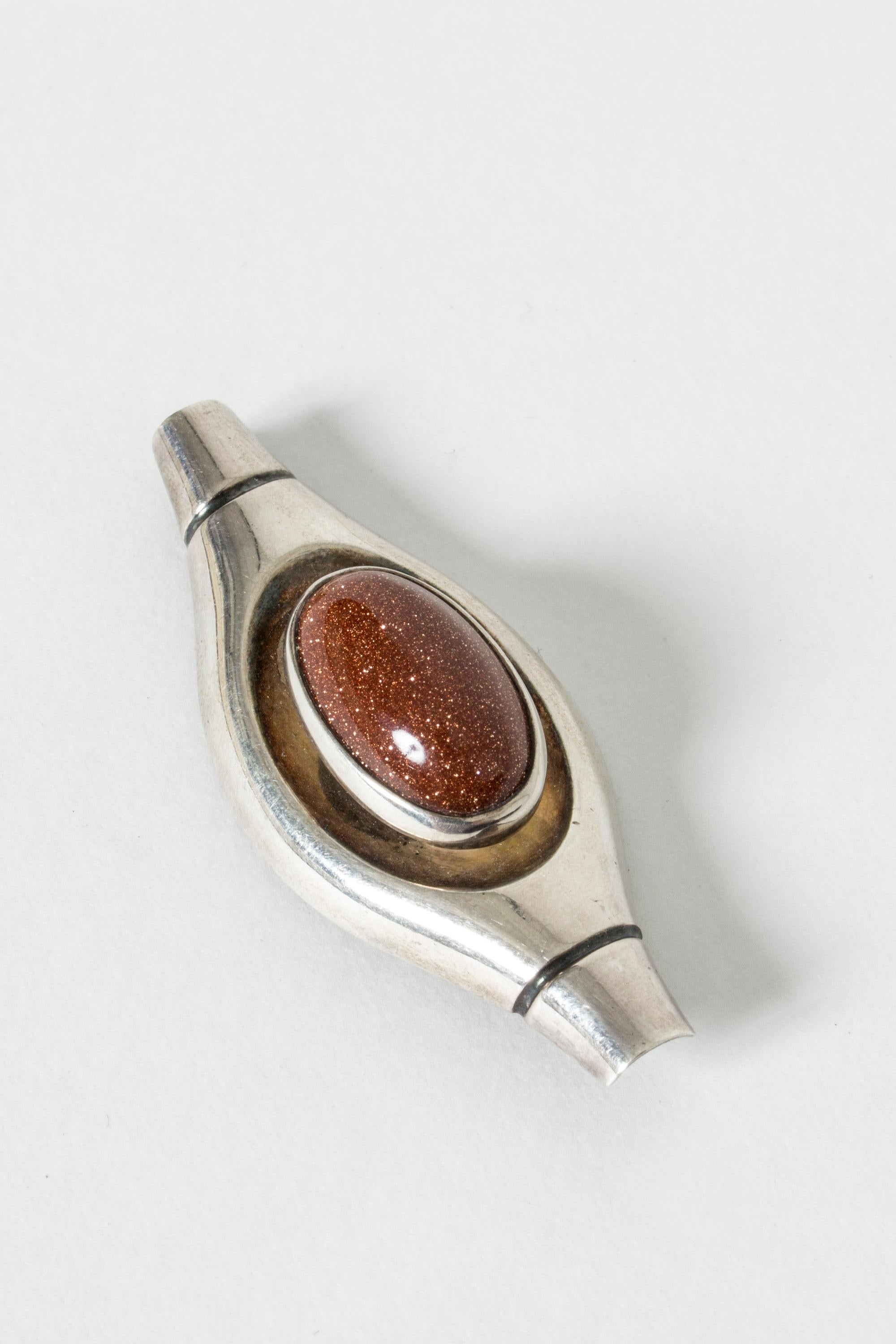 Silver and goldstone brooch in a cool, streamline design by Elis Kauppi for his own firm Kupittaan Kulta Oy, one of Finland’s foremost modernist jewelers of the 1950s and 1960s.