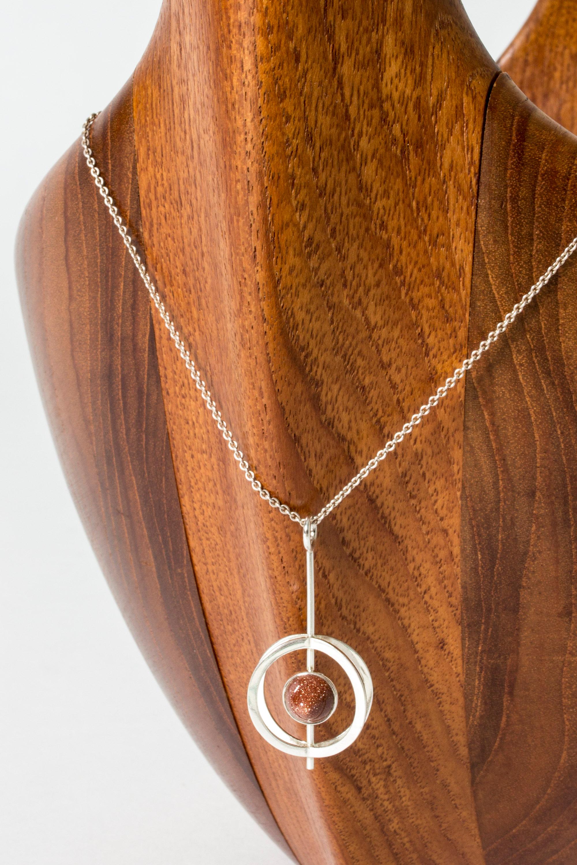 Beautiful silver pendant by Elis Kauppi, with a bullet cut goldstone in the middle. Open, graphic design that is striking while being a neat, easy to wear design.