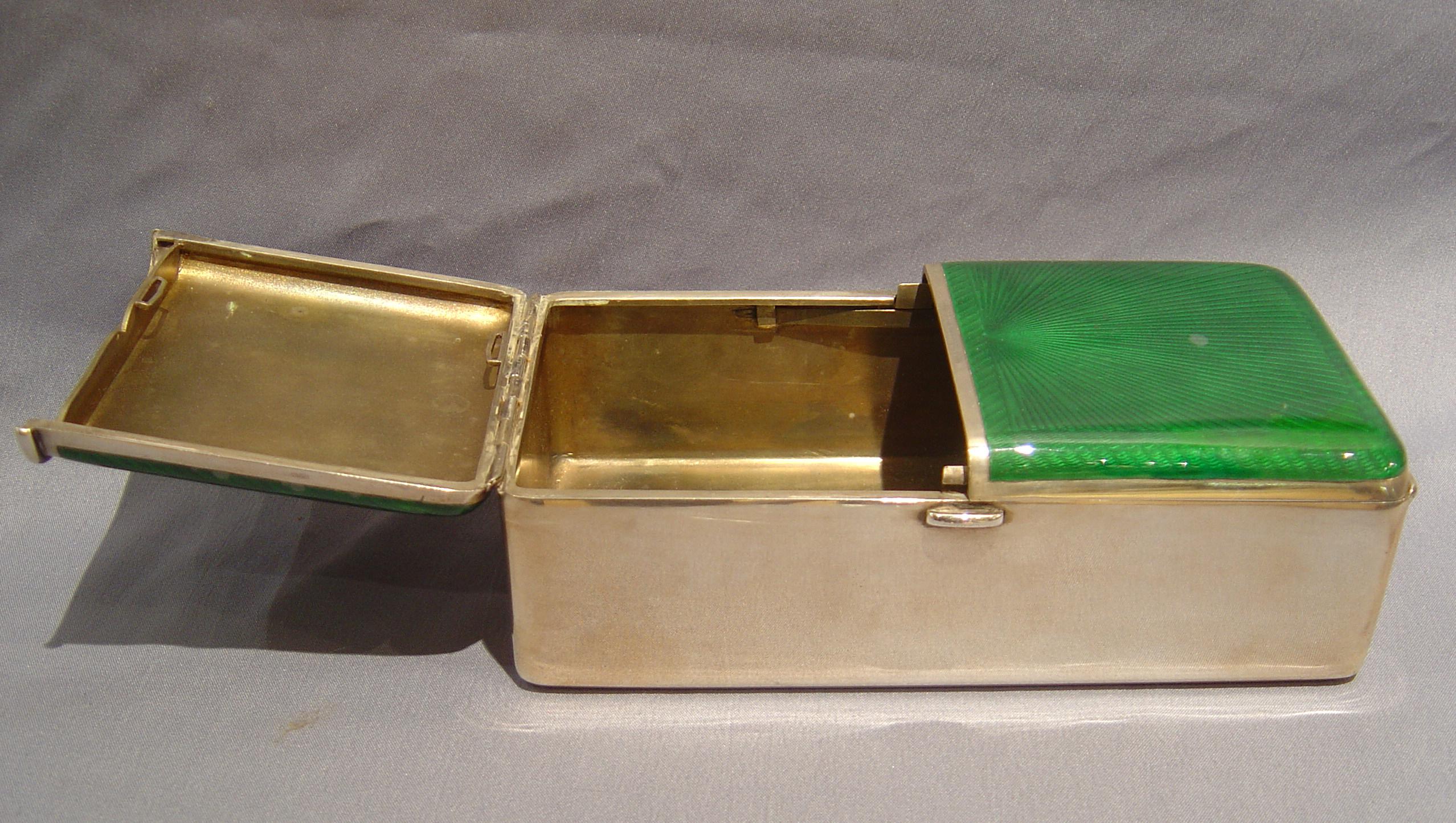 An attractive silver and green guilloche enamel cigarette box. The lids with spring loaded release.