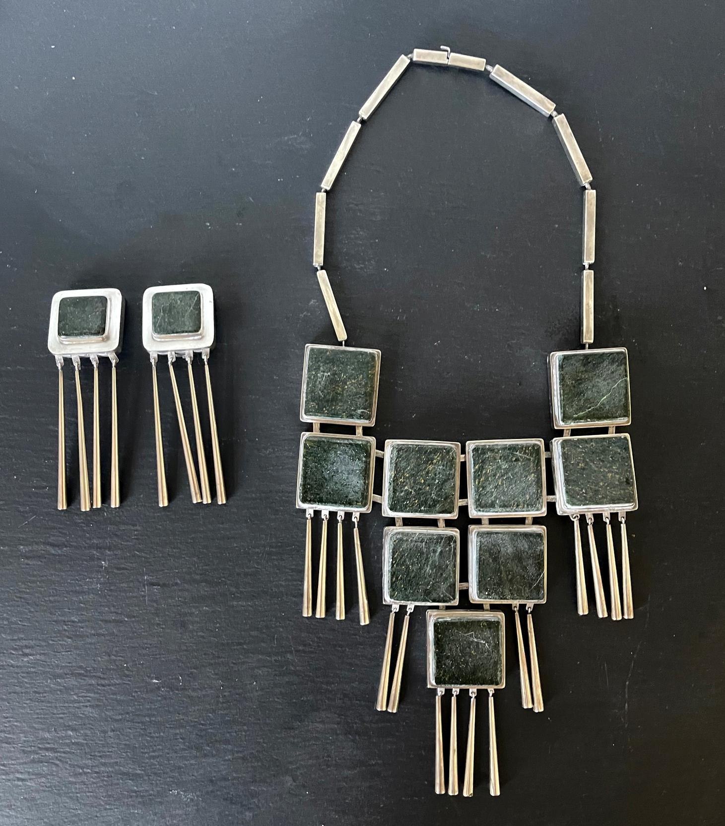 A bespoken jewelry set including a necklace and a pair of clip-on earrings crafted by Graziella Laffi, Lima, Peru, circa 1970. The suite features linked square of green hardstone (appears to be a jade color granite or marble) set in the sterling