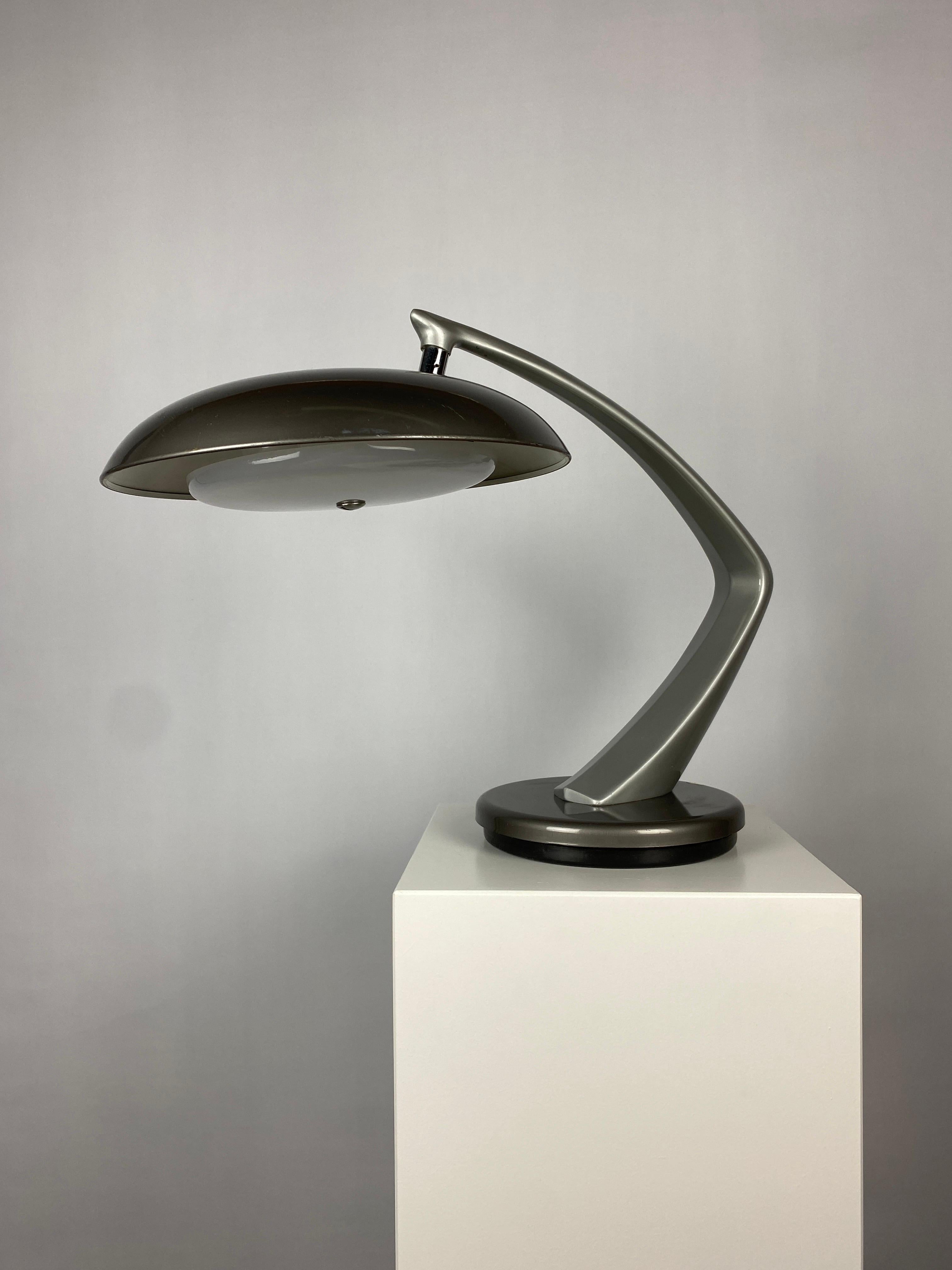 What a beauty! This is one of the classics in silver and dark grey colour. The FASE Boomerang 64 desk light is manufactured in the 1960's by the company FASE Madrid. 

The base can normally spin in a 360º rotation but this one does not fully spin