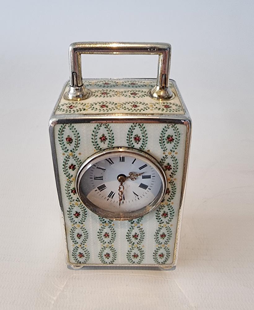 A very fine silver and guilloche enamel with overpainted roses miniature carriage or boudoir clock by Georg Adam Scheid. The 8 day french movement with integral winding key. The case stamped on the underside and inside back door 900 for silver