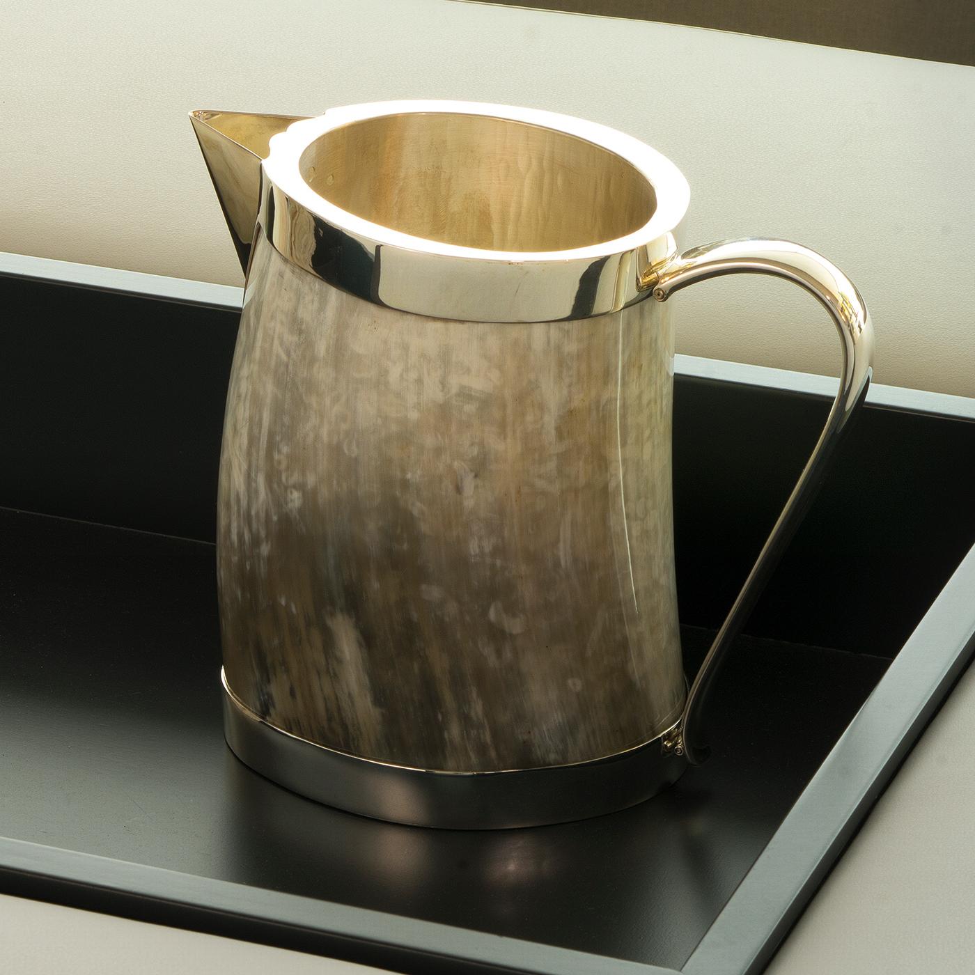 Part of the Horn collection, this superb pitcher will be the focal point of a modern table setting during formal dinners and holiday parties. Handcrafted of 925 silver, the interior has a hand-hammered surface while the sharply angled spout, the