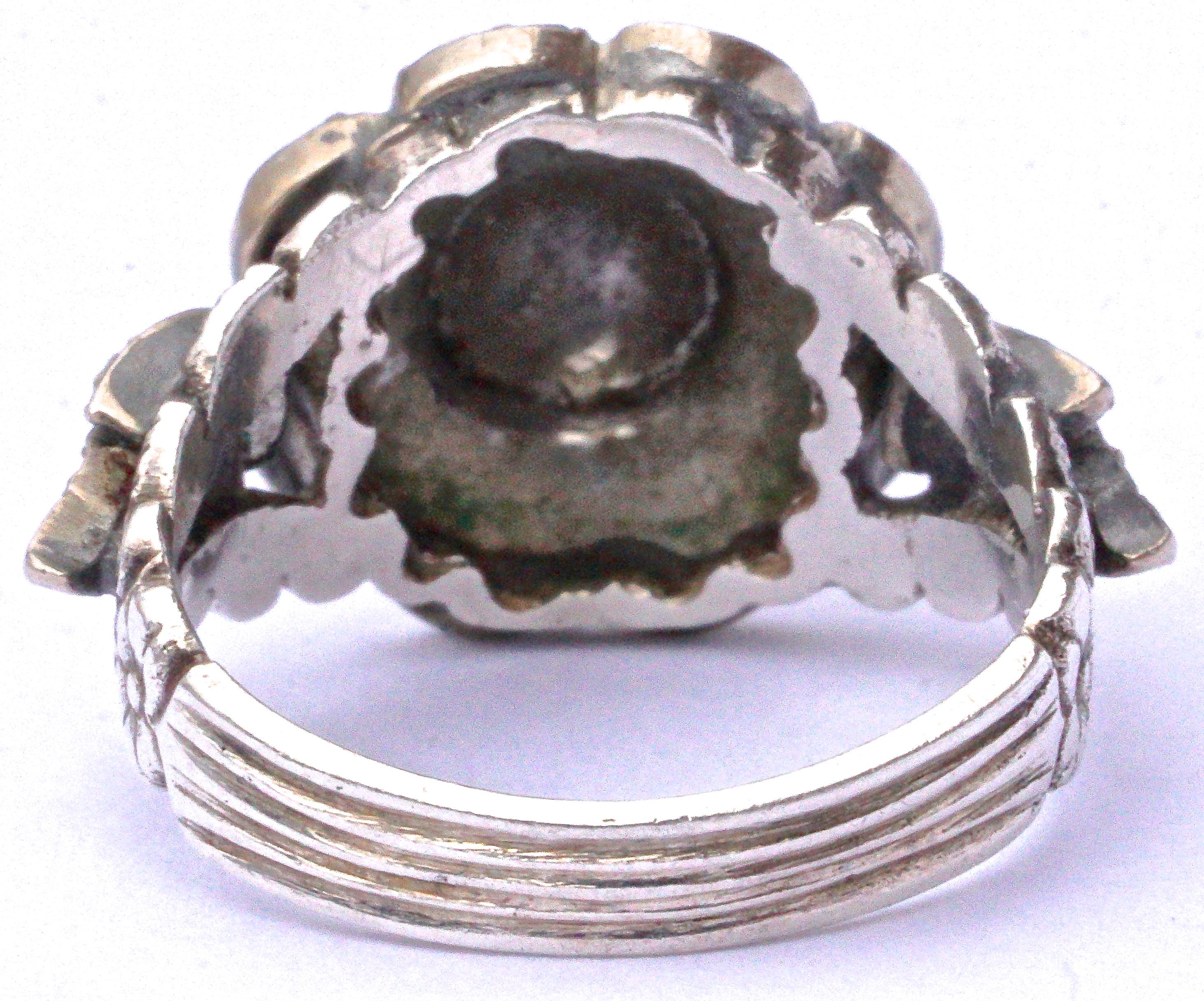 Wonderful and detailed silver flower ring set with marcasites, and featuring a lovely flower and line design to the band. The marcasites are all intact except for one marcasite in the centre of the flower that is part missing. We have left as is