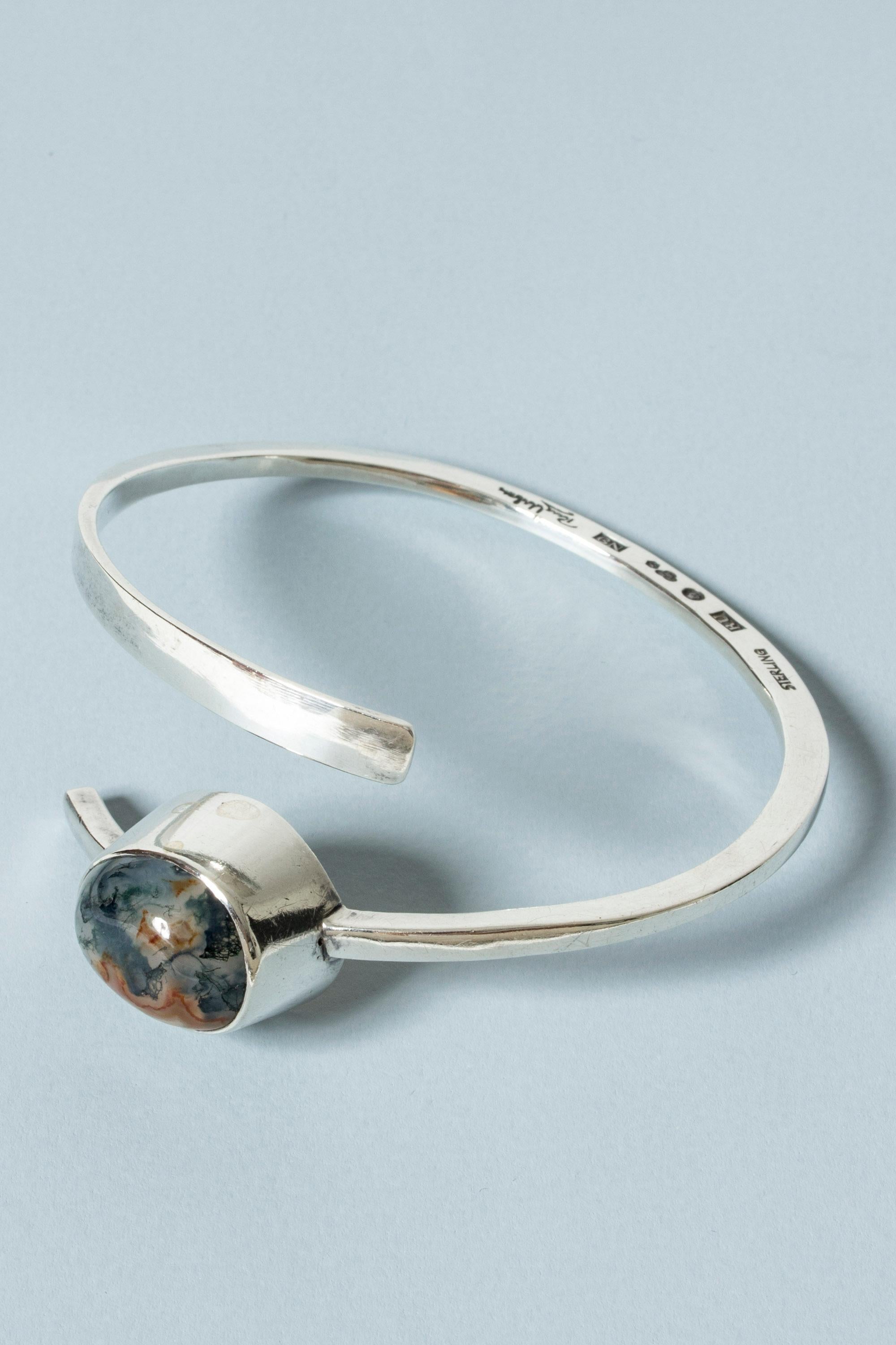 Striking silver bracelet by Rey Urban, in a spiraling design that can be worn pinched around the arm. Adorned with a mesmerizing, large moss agate stone.