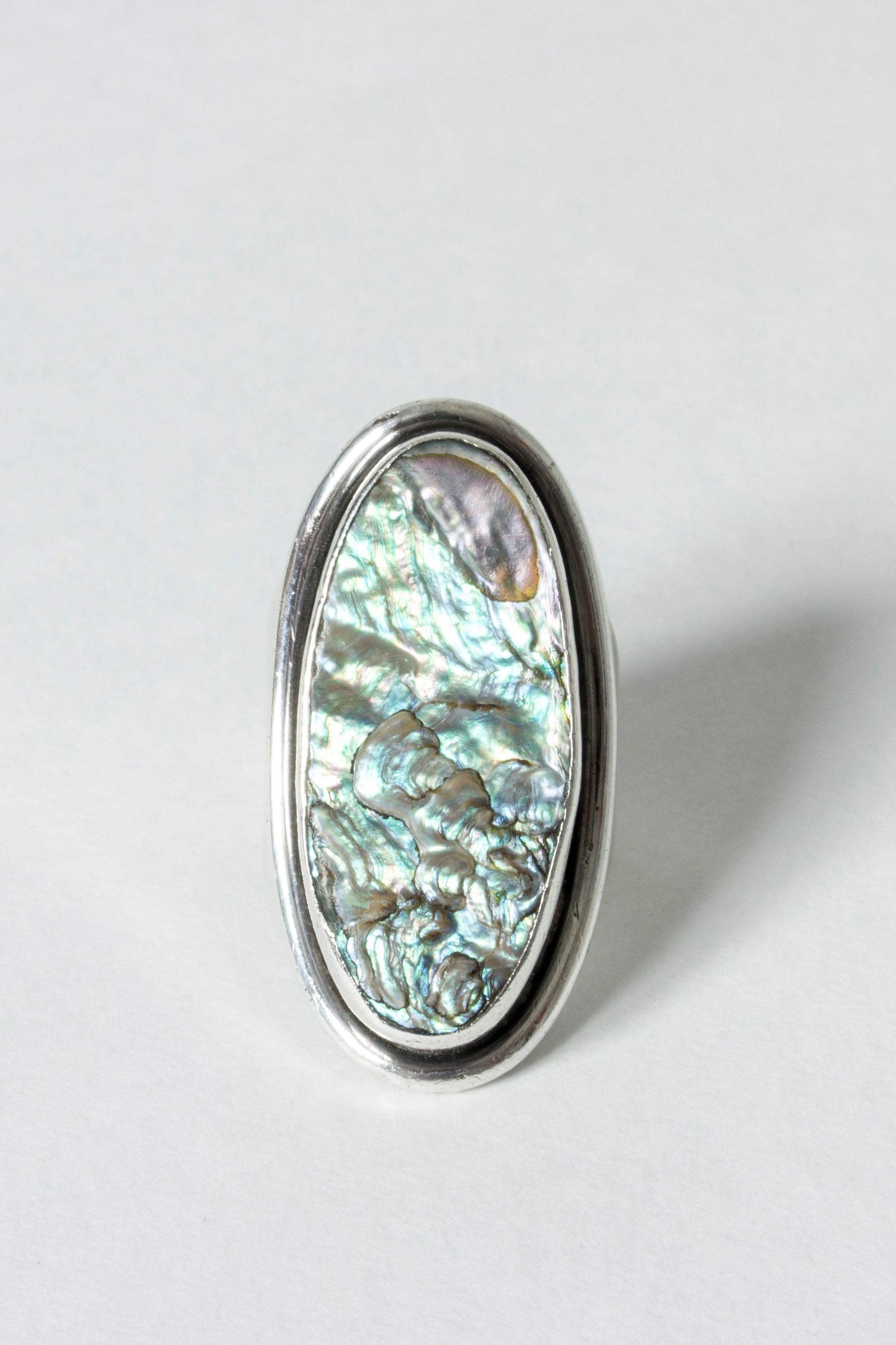 Striking silver ring by Carl Ove Frydensberg, with a large, elongated oval with mother of pearl. Beautiful combination of materials, dreamy shine and movement in the mother of pearl.