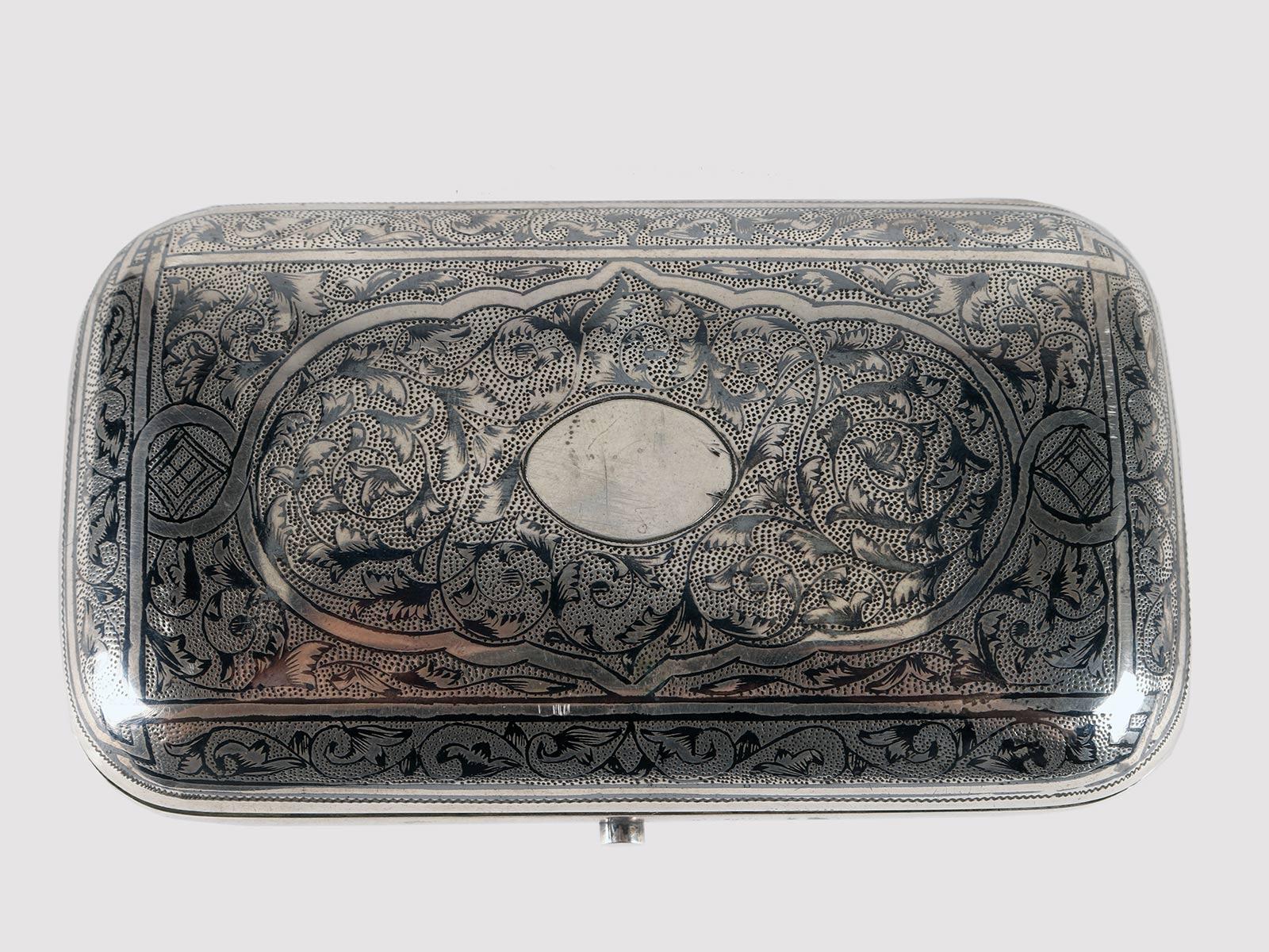 Silver and niello snuffbox. The tobacco box, made of 84 zolotnik silver (875/1000) is rectangular in shape with a soap bar body, with rounded corners and rounded profiles. The entire decoration of the box is made with niello.
The upper part is