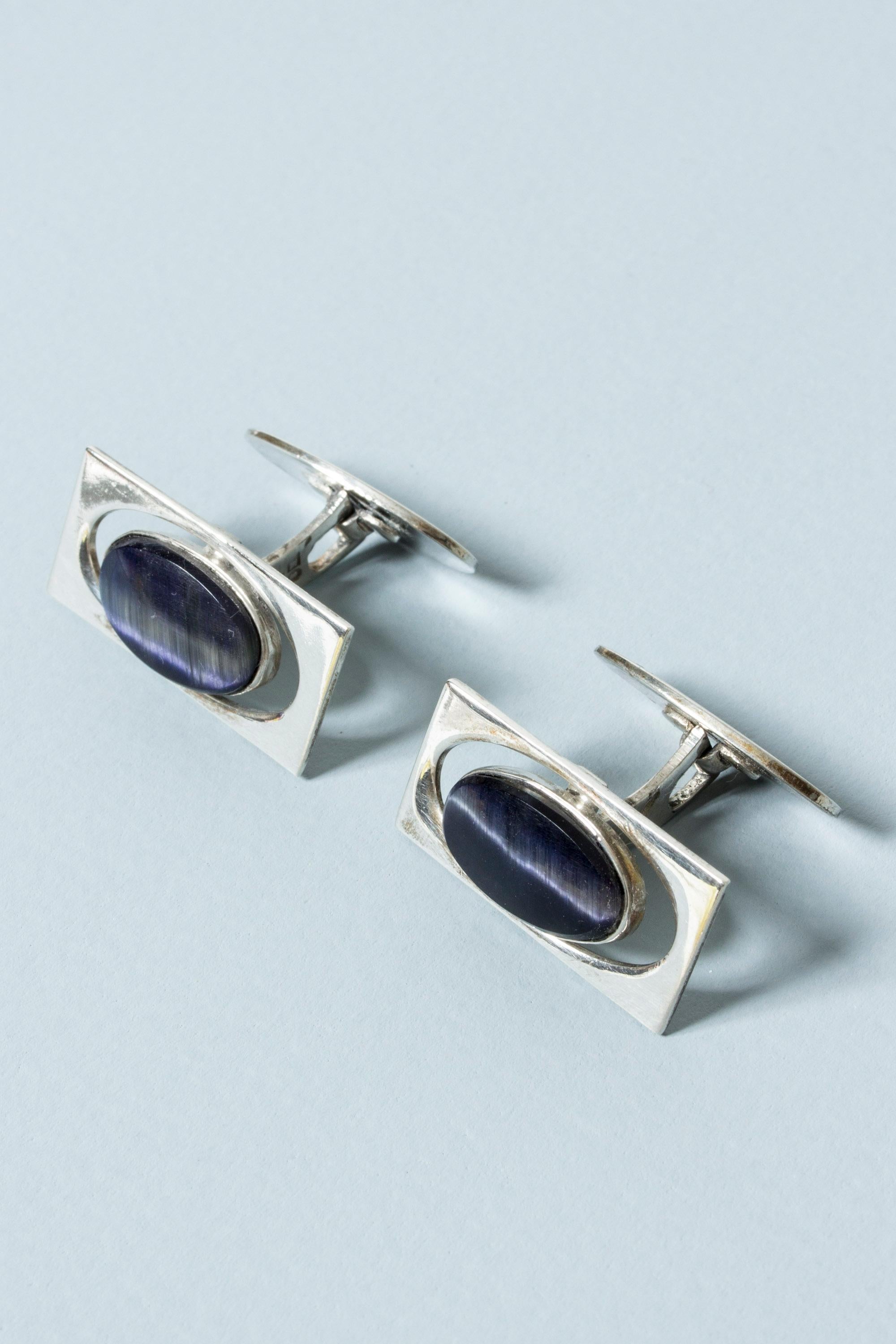 Pair of elegant silver cufflinks from Kaplans, with oval purple semiprecious stones in a cutout frame. Mesmerizing stones with a white sheen through the middle.