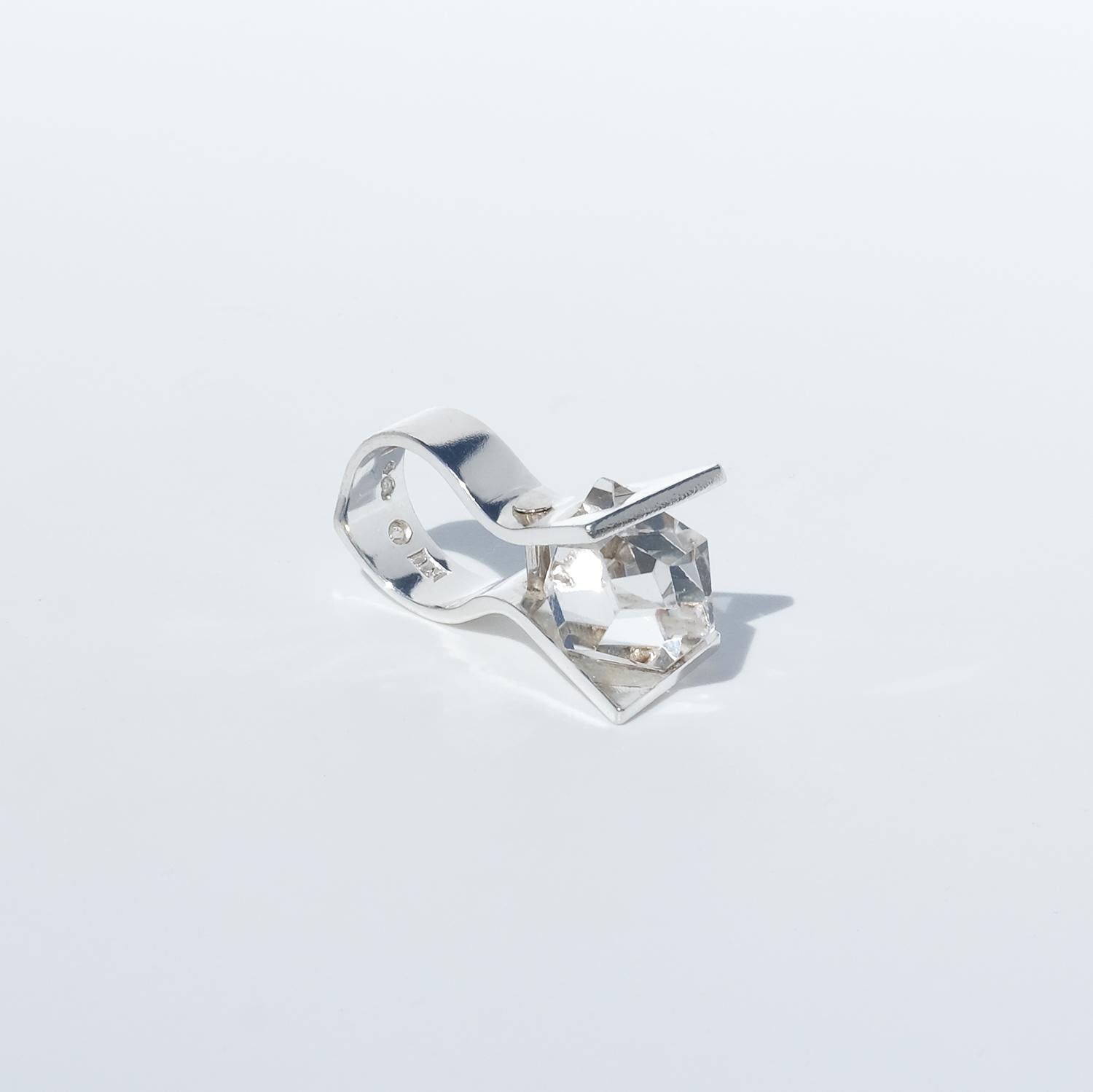 Questo anello vintage in argento sterling presenta un grande cristallo di rocca dal taglio fantasy incastonato tra due sostanziose piastre d'argento che si estendono verso l'alto dalla fascia. Queste piastre angolate incorniciano la pietra e sono