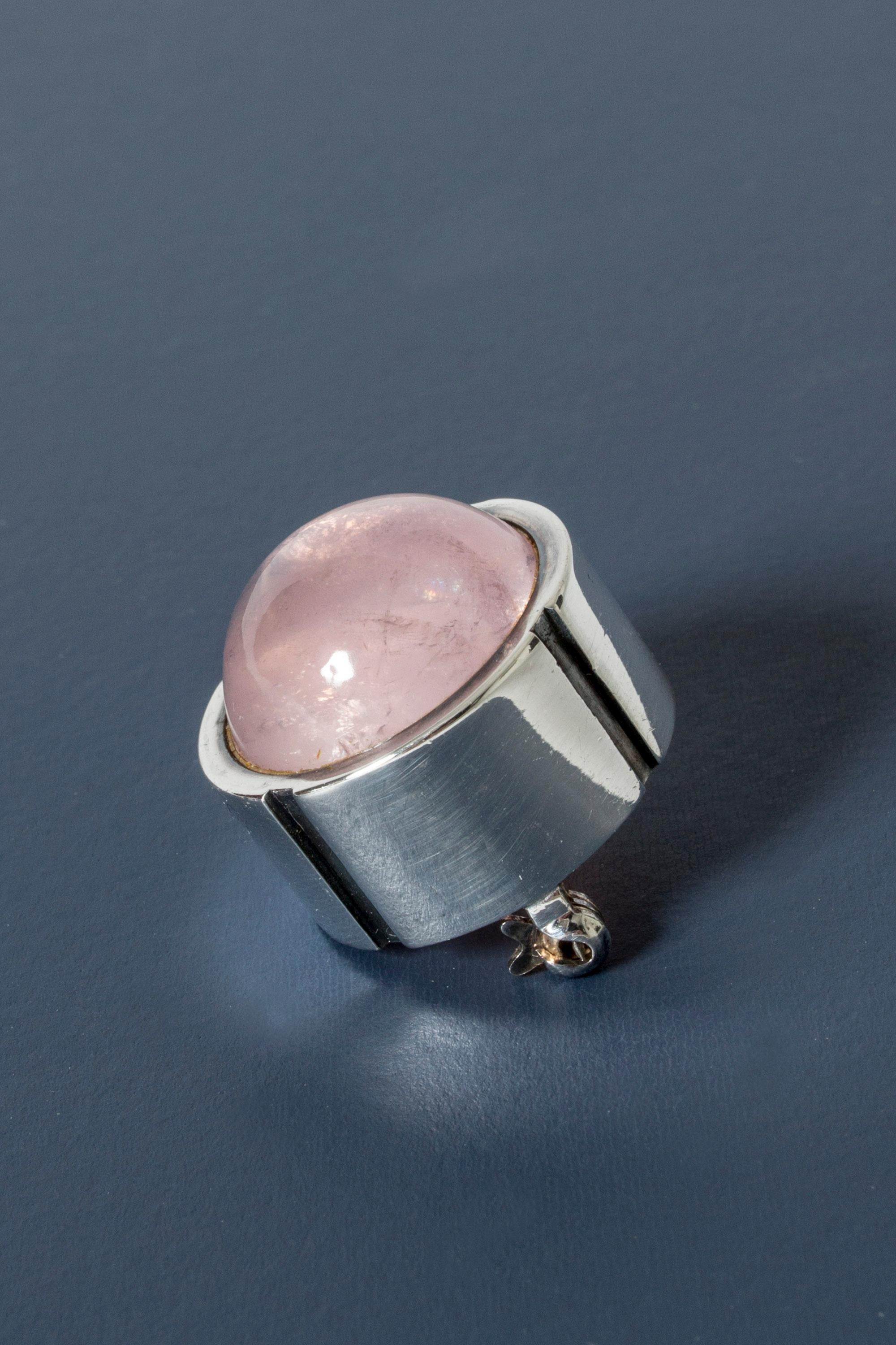 Delectable little brooch by Heikki Kaksonen, made from silver and rose quartz. Protruding, round cut stone that looks like a piece of candy. To be worn on a sturdy fabric that can carry the brooch’s weight.