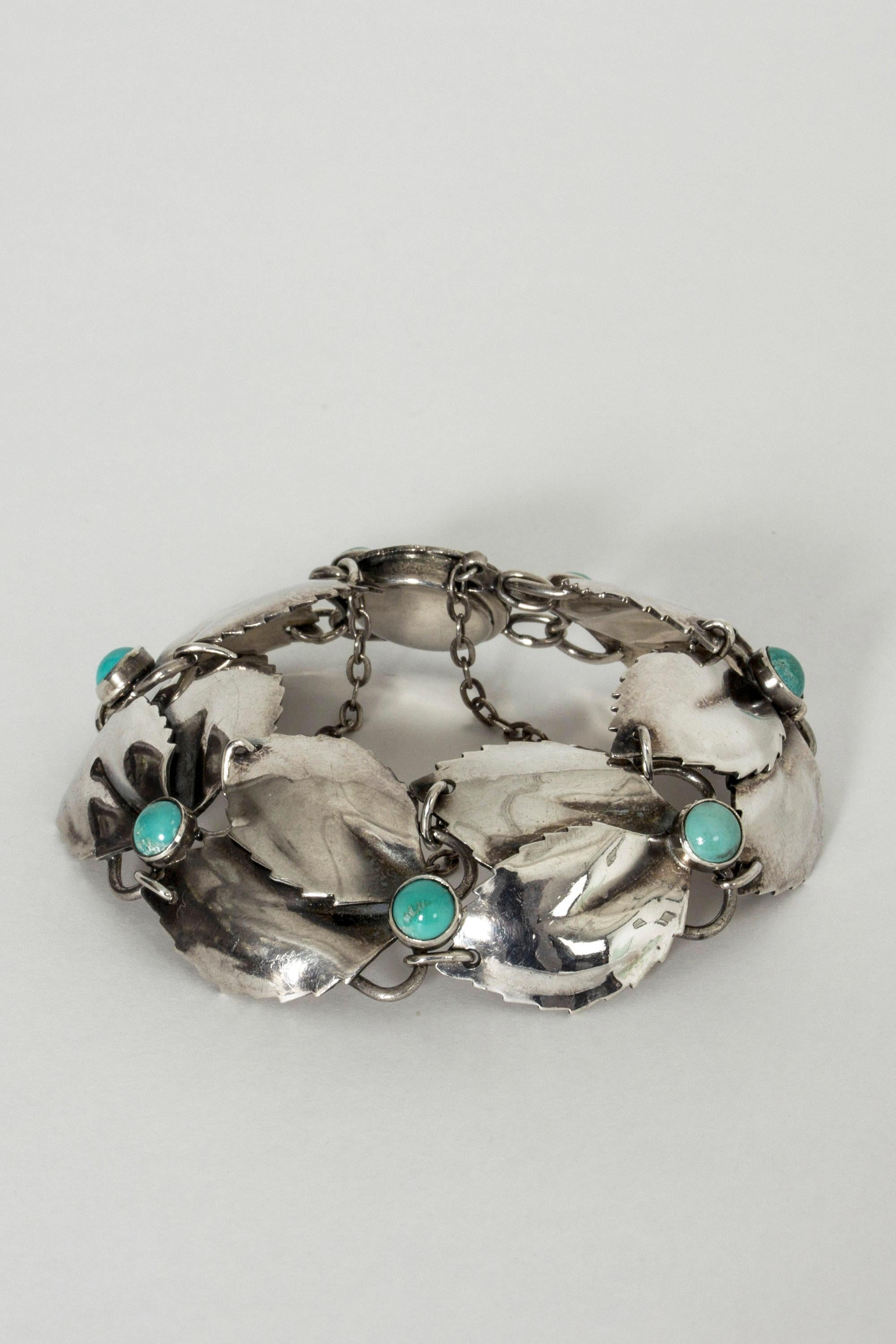 Elegant silver bracelet by Gertrud Engel, made in the shape of leaves adorned with turquoise stones. Beautiful lock with a security chain.