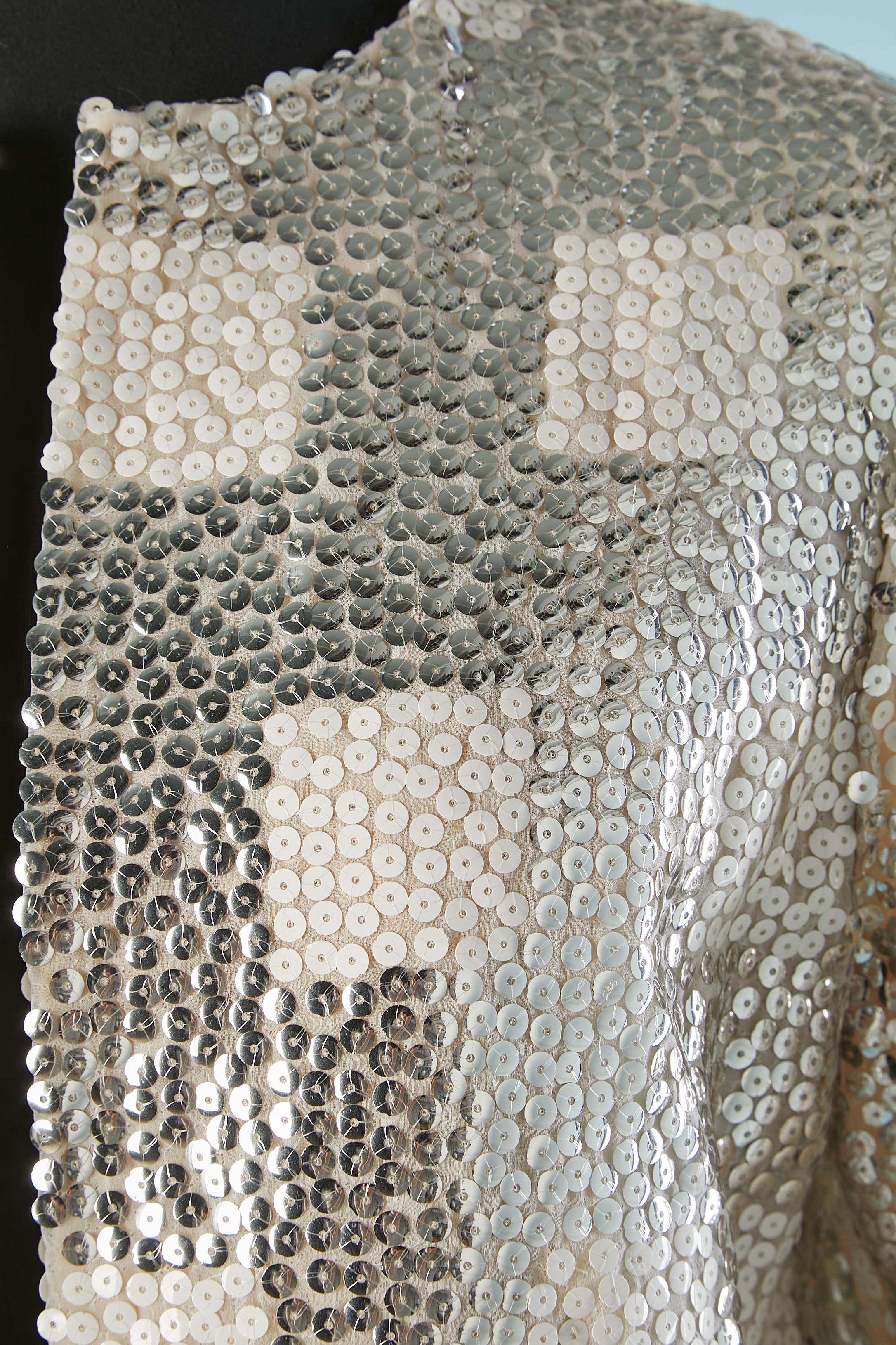 Giacca da sera in paillettes bianche e argento con tasca su entrambi i lati. 
Non c'è l'etichetta della composizione del tessuto, ma la fodera è probabilmente in acetato. 
TAGLIA 40 / L. 