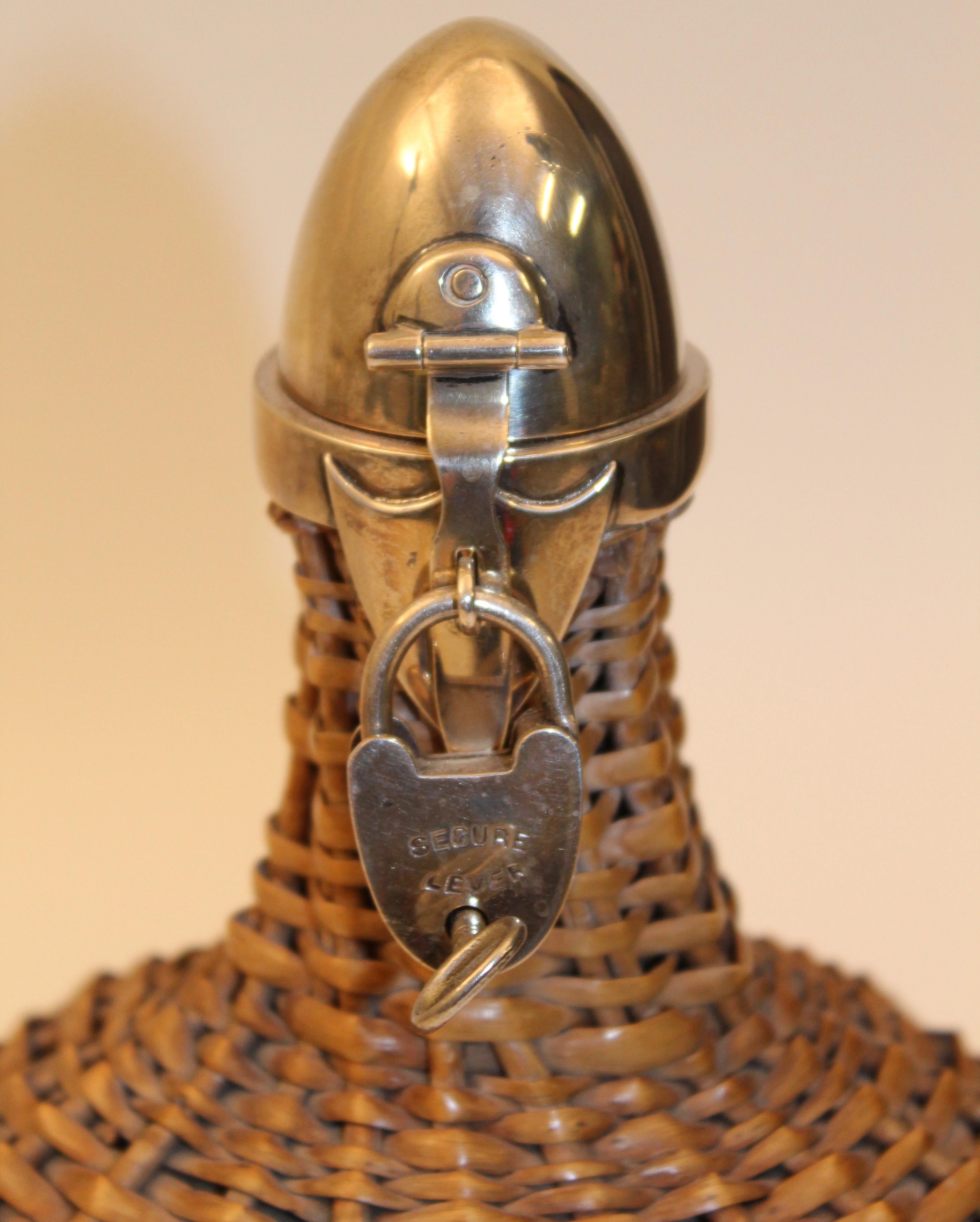 A silver mounted locking wicker covered bottle, stamped for Heath & Middleton in Birmingham, 1899.
With a curved wicker handle to the back the body completely encapsulated in the wicker-work, topped with a silver cap, with a small shaped lock and