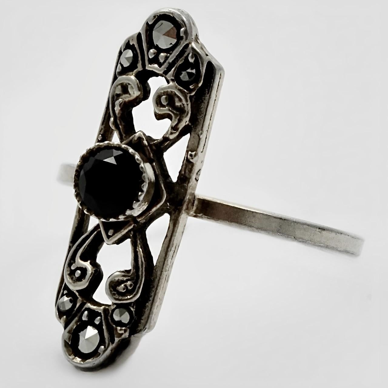 Beautiful 835 silver Art Deco ring, featuring a centre black glass faceted stone and marcasites set into black enamel. Ring size UK O 1/2, US 7 1/4, inside diameter 1.85 cm / .72 inch.

This lovely silver vintage ring is circa 1930s.