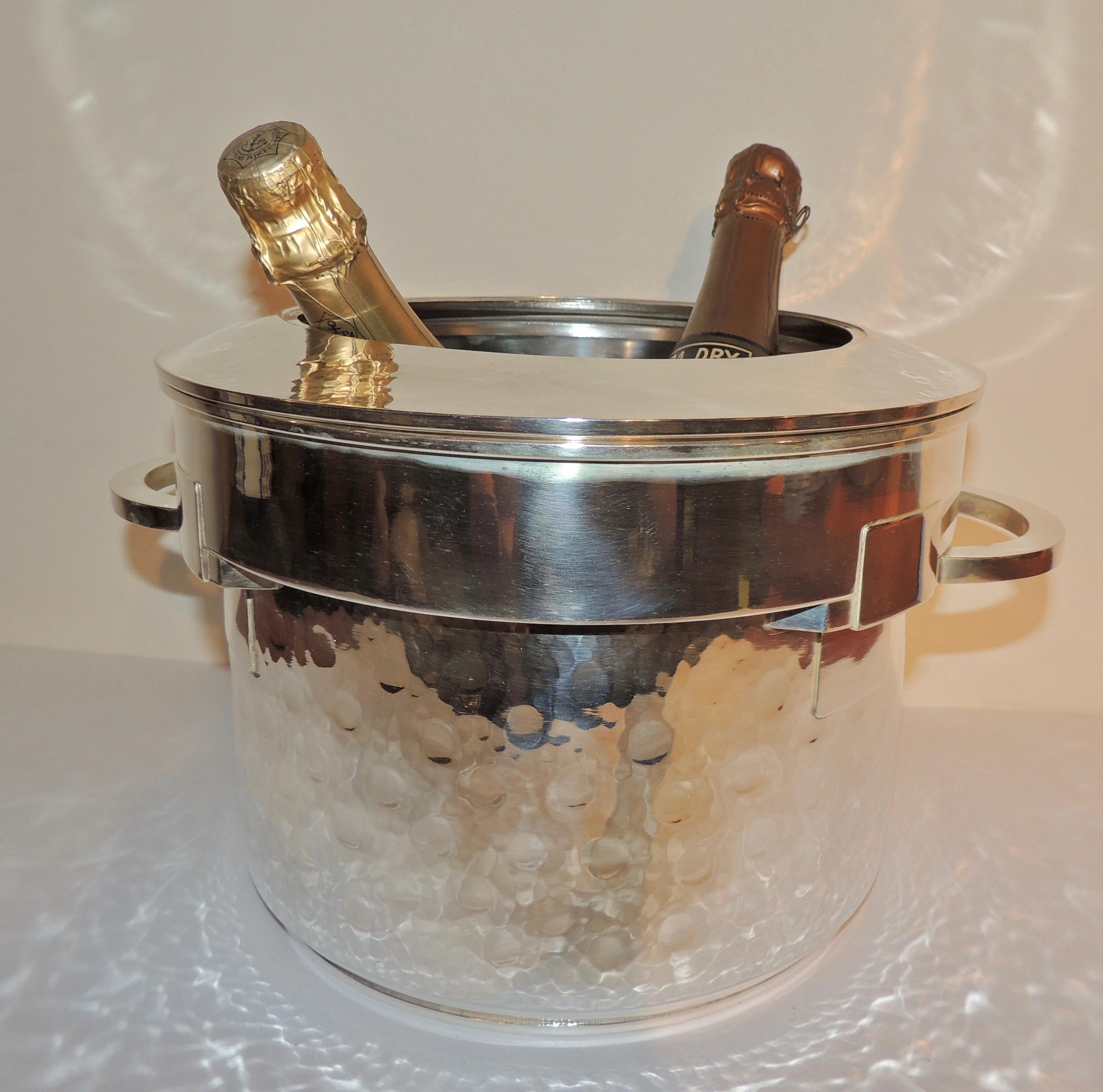 An Art Deco, hand-hammered silver champagne cooler…large enough to hold two or even three bottles with a separate, detachable “ring” of silver that gives it some flexibility in the number of bottles that can be nestled in it. The decorative element