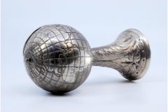 Silver ashtray in the shape of a globe w/ flowers & palms engraved on the column