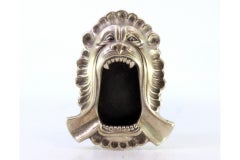 Silver ashtray in the shape of a lion's mouth w/ reliefs & two cigarette holders