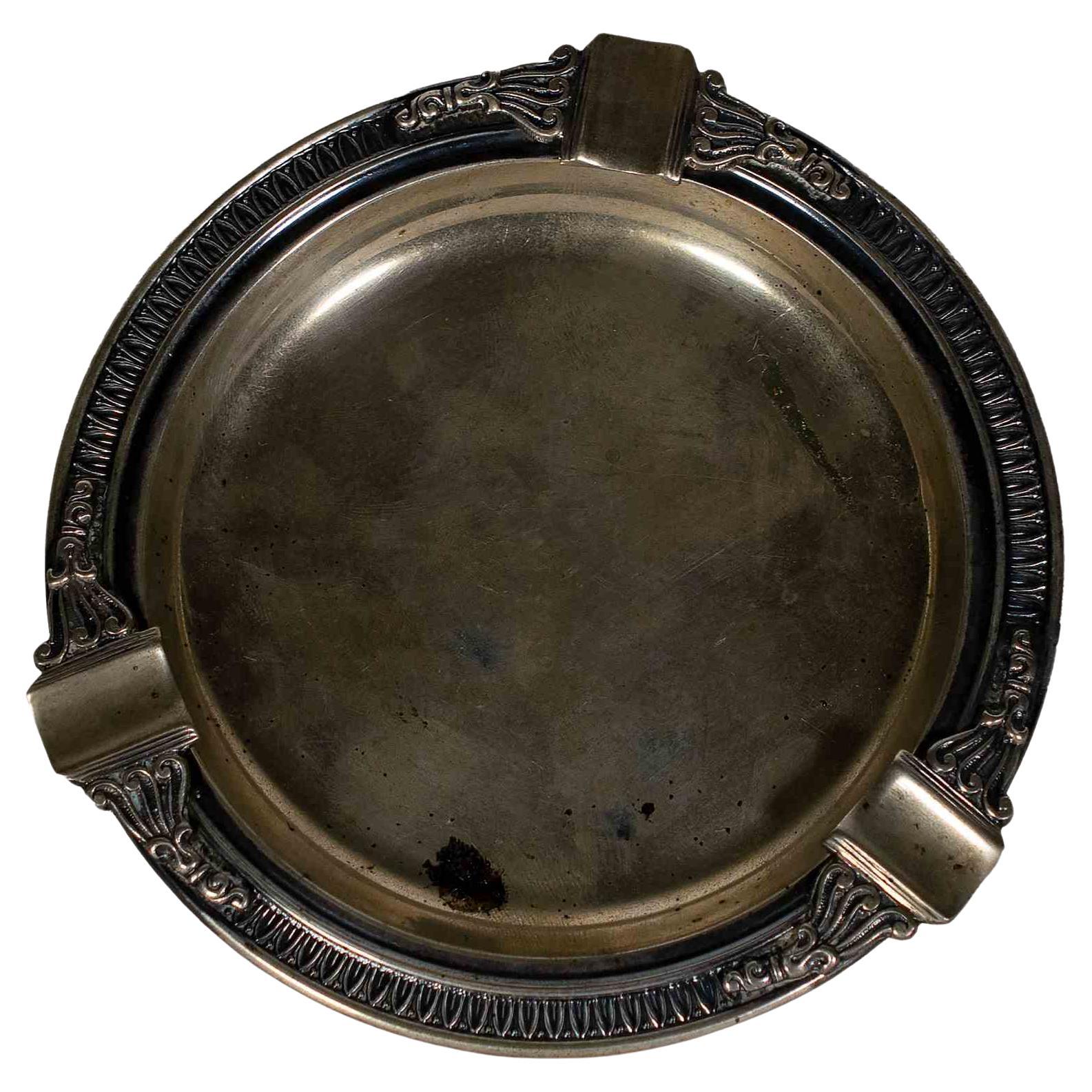 El cenicero de plata es un objeto decorativo de plata realizado por un artista de mediados del siglo XX.

Un cenicero muy elegante decorado con cenefa de palmetas estampadas.

Buen estado, excepto por una mancha.