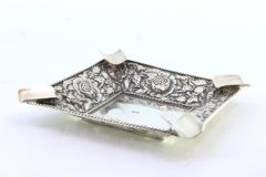 Silver ashtray w/ embossed floral motifs, corded frieze & four cigarette holders