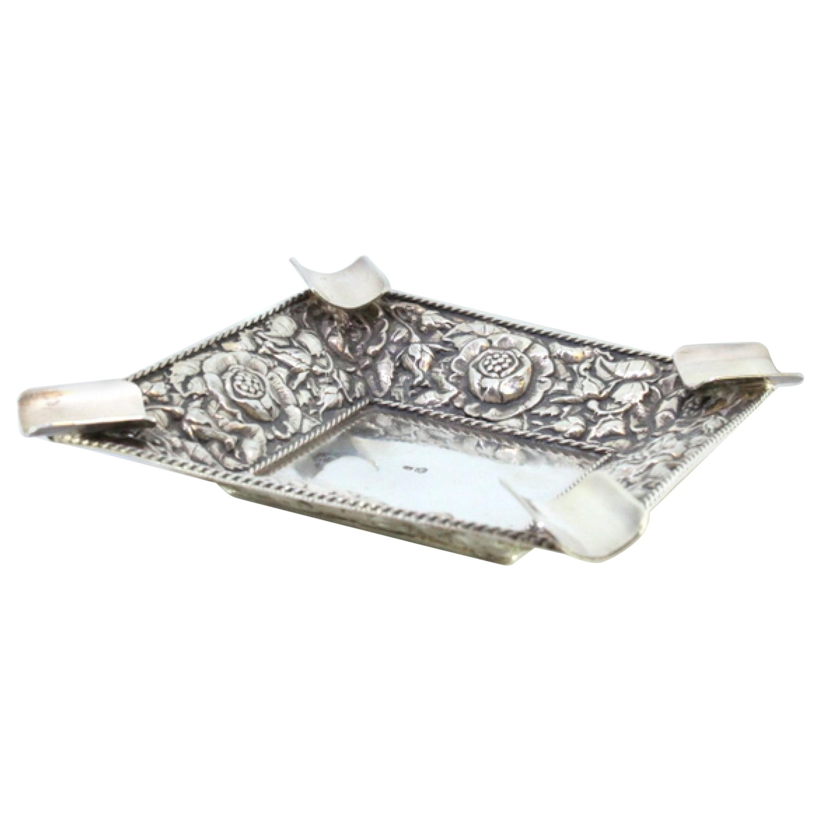 Silver ashtray w/ embossed floral motifs, corded frieze
four cigarette holders