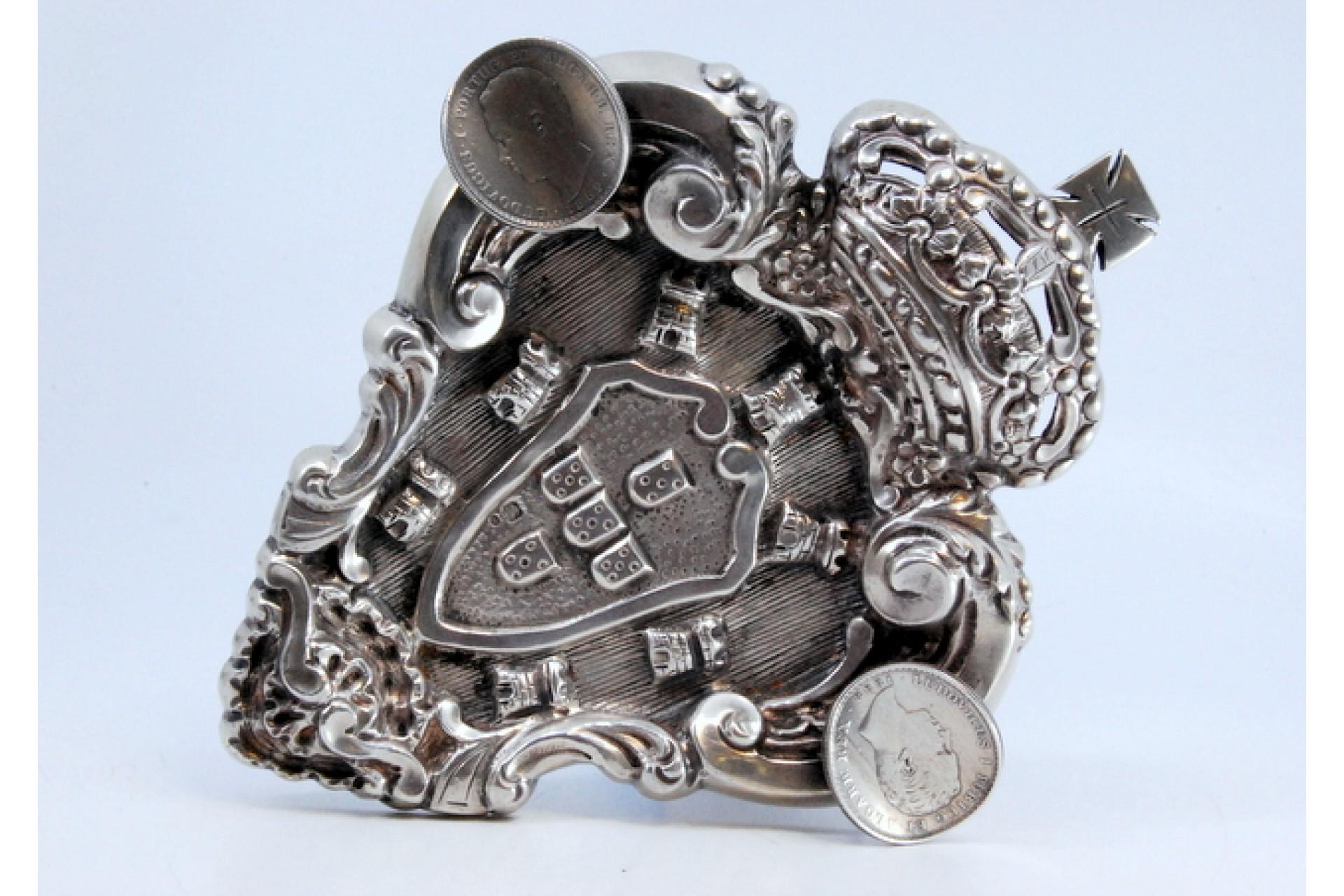 Description : Cendrier en argent avec les armoiries du Portugal et deux pièces de 500 reis de D. Luís. Métal : Argent. Origine : Portugais. Poinçon : aigle debout. Poids : 127,76 grammes. Dimensions : 17.4x14.6cm : 17.4x14.6cm. Contenu : 833/1000.