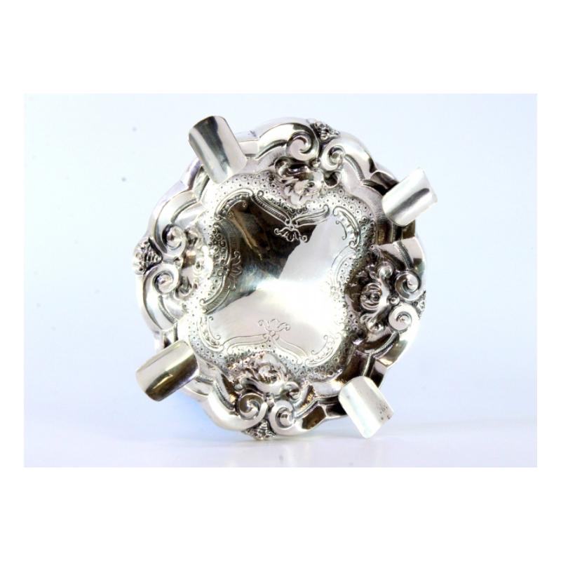 Description: Silver ashtray with reliefs and engravings, four cigarette holders. Metal: Silver. Origin: Portuguese. Brand: Absent. Weight: 99.15 grams. Dimensions: 16cmx16cm. Content: 833/1000. Assay Mark: Absent. Additional information: Good