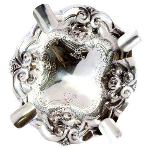 Silver ashtray with reliefs and engravings, four cigarette holders