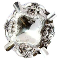 Silver ashtray with reliefs and engravings, four cigarette holders