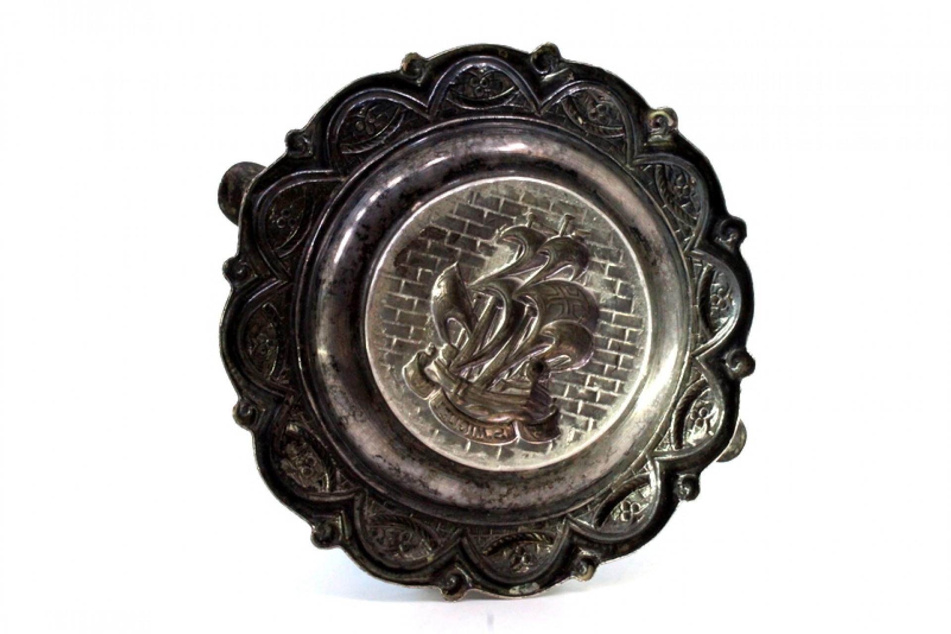 Description : Cendrier en argent avec des reliefs évoquant la caravelle S. Miguel au centre et deux porte-cigarettes. Métal : Argent. Origine : Portugais. Poinçon : aigle debout. Poids : 92,06 grammes. Dimensions : 13,2 cm x 13,2 cm : 13.2cmx13.2cm.