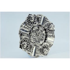 Silver ashtray with shell-shaped reliefs and applications to support cigarettes