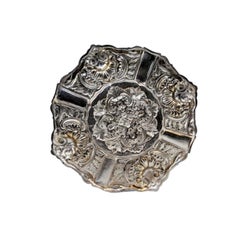 Silver ashtray with shell-shaped reliefs and applications to support cigarettes