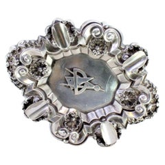 Silver ashtray with shells, reliefs, four rests, and Masonic symbol Silver ashtray with shells, reliefs, four rests, and Masonic symbol