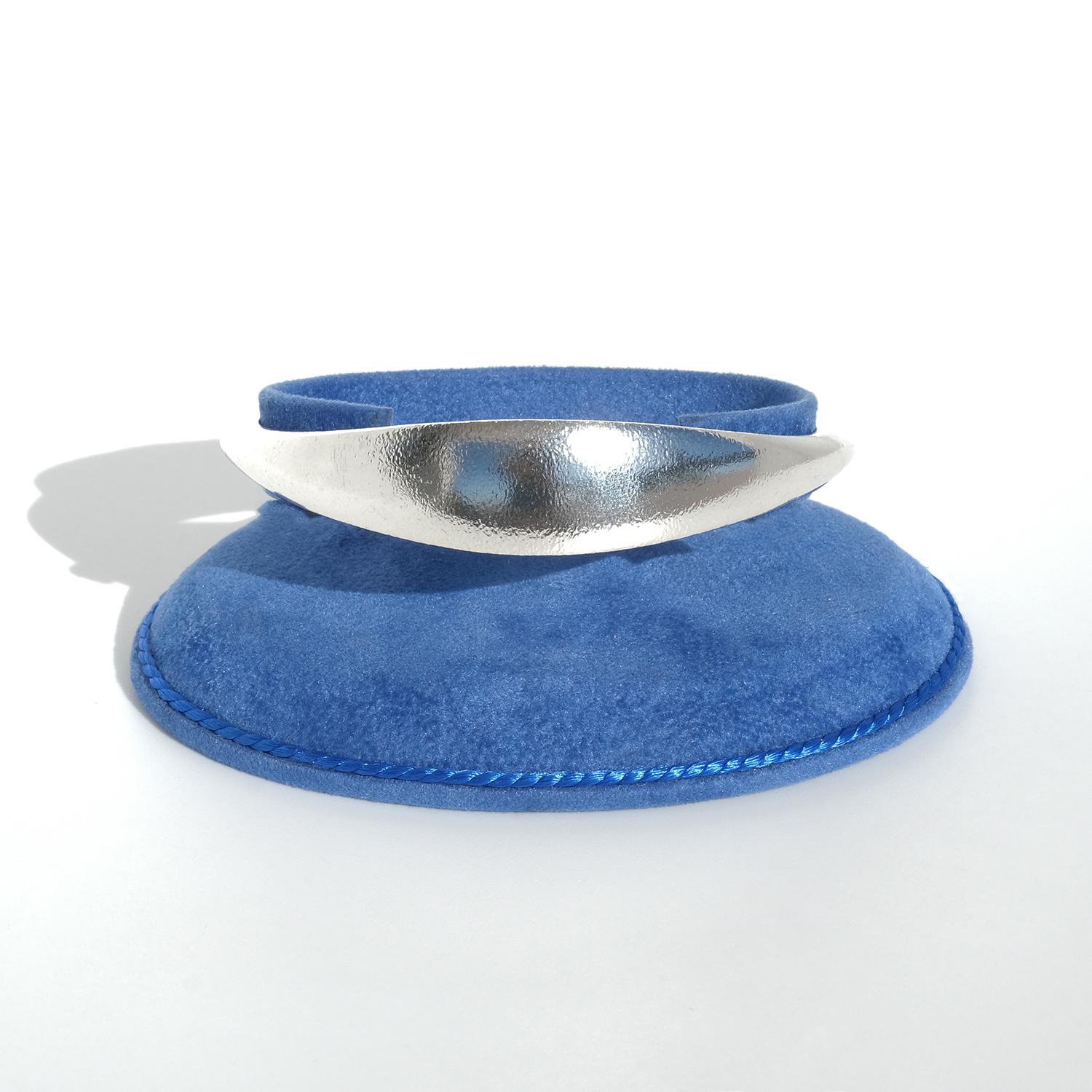 Questo braccialetto in argento presenta un design elegante e scultoreo che alterna due sezioni più ampie e leggermente bombate a due aree più strette con curve più nette e pronunciate, creando un flusso dinamico.

La superficie leggermente