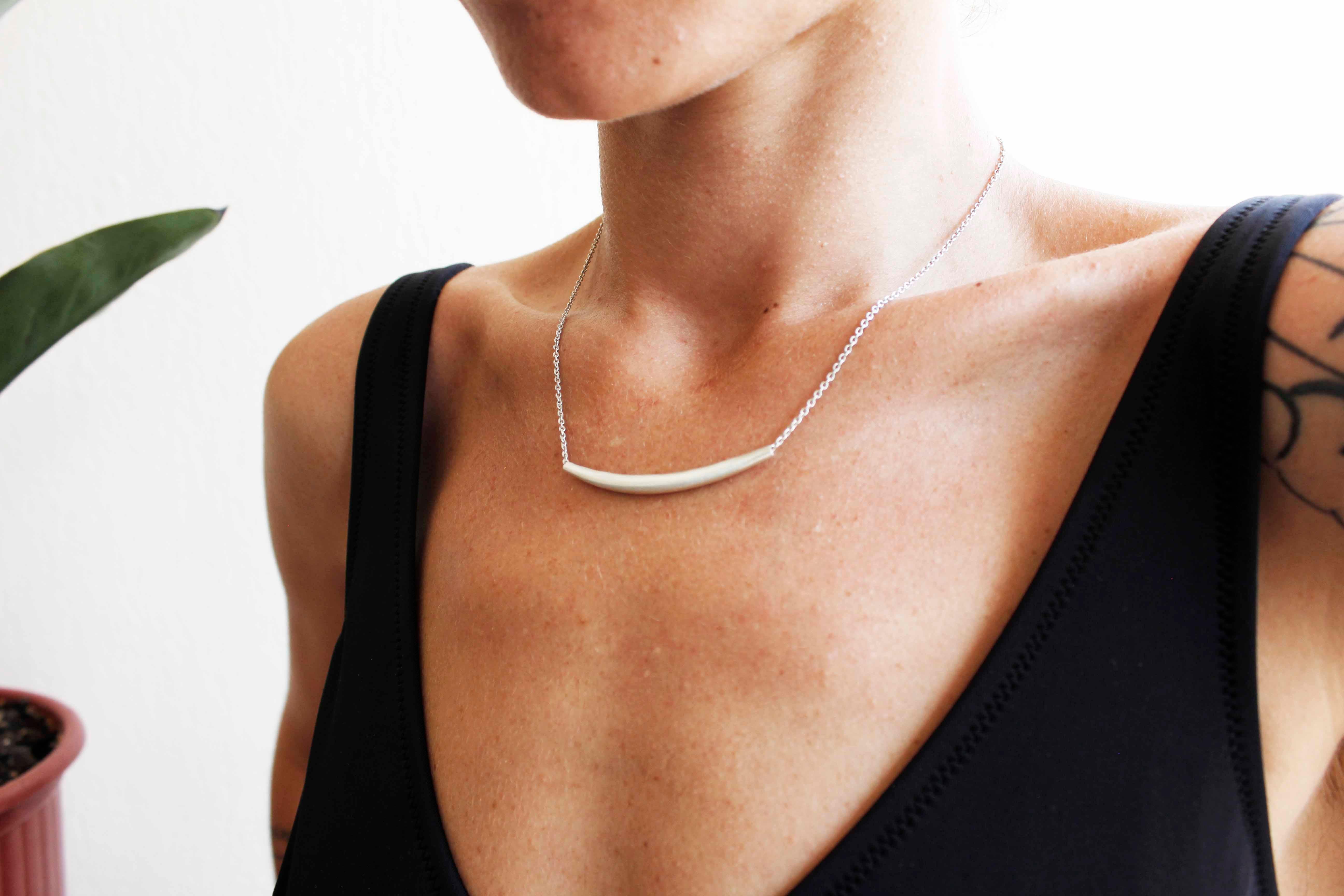 The Silver bar necklace is handmade from fine silver, and is great for layering.

A modern, curved free flowing tube that moves with you to always sit in place.

Bar length: 5cm
Chain length: 44cm
