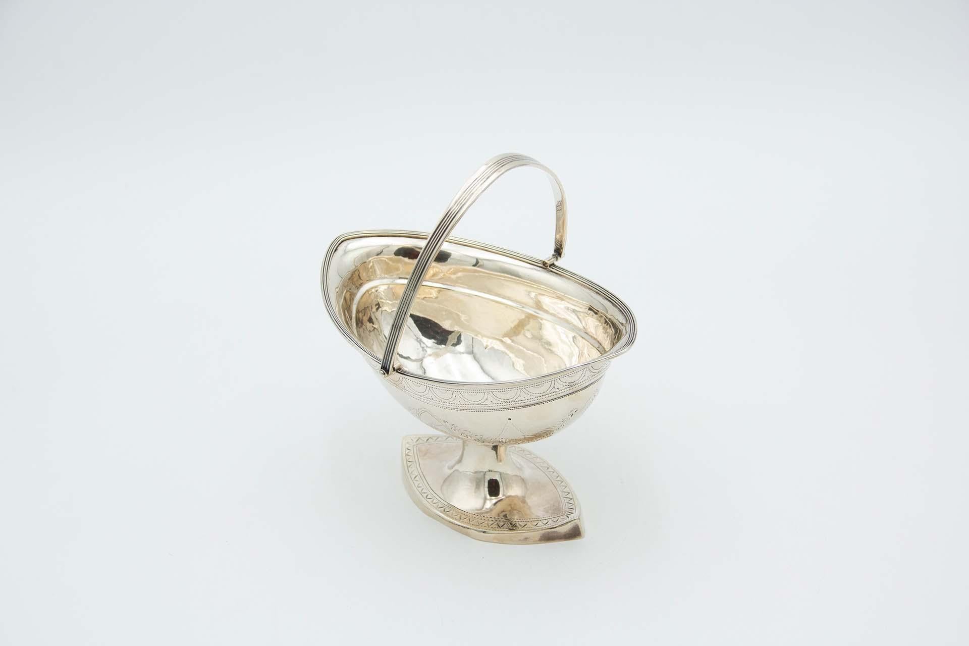 Descrizione: Cestino d'argento con ghirlande incise e stemma araldico con manico inclinabile e perline. Metallo: Argento. Origine: irlandese. Marchio: Dublino. Peso: 238,63 grammi. Dimensioni: 17cmx18,7cm. Contenuto: 925/1000. Marchio di controllo: