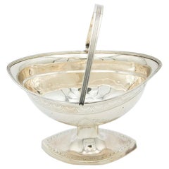 Silver basket with low reliefs on a high foot