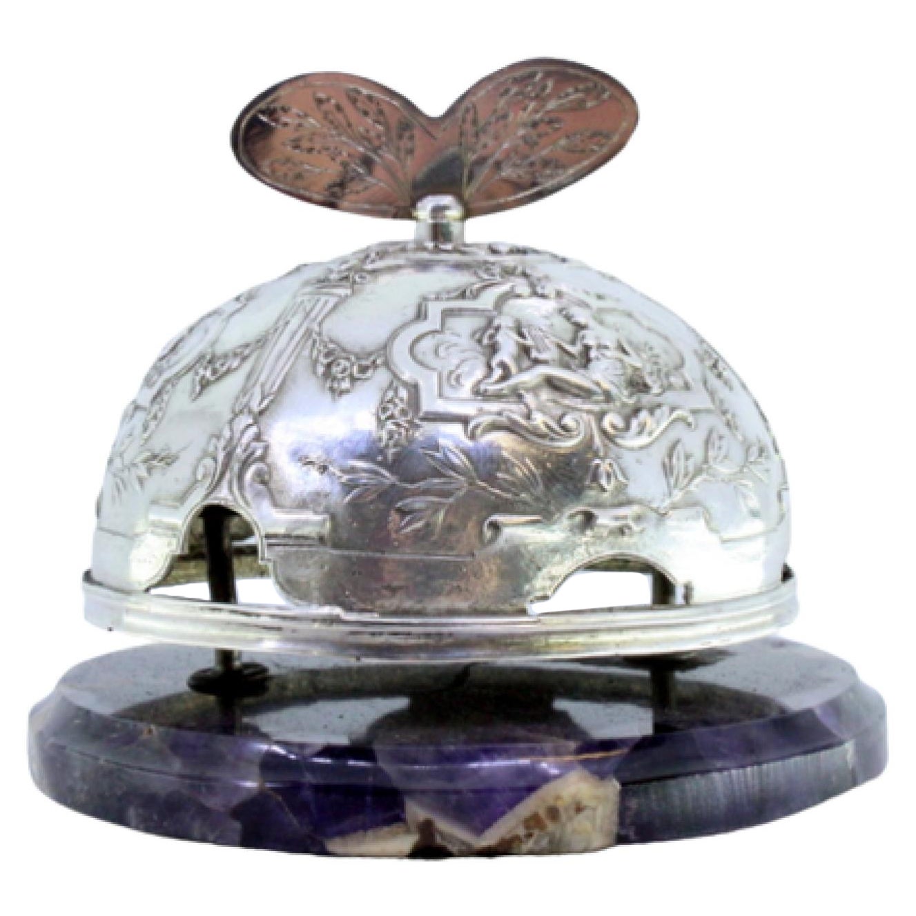 Silver bell with pierced angelic motifs on marble base