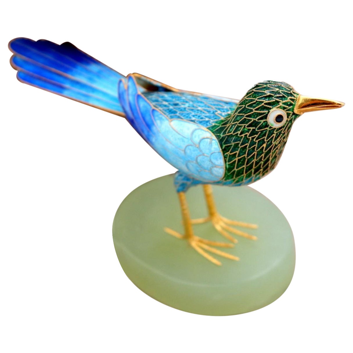Silver bird covered in colored enamel on an elliptical stone base