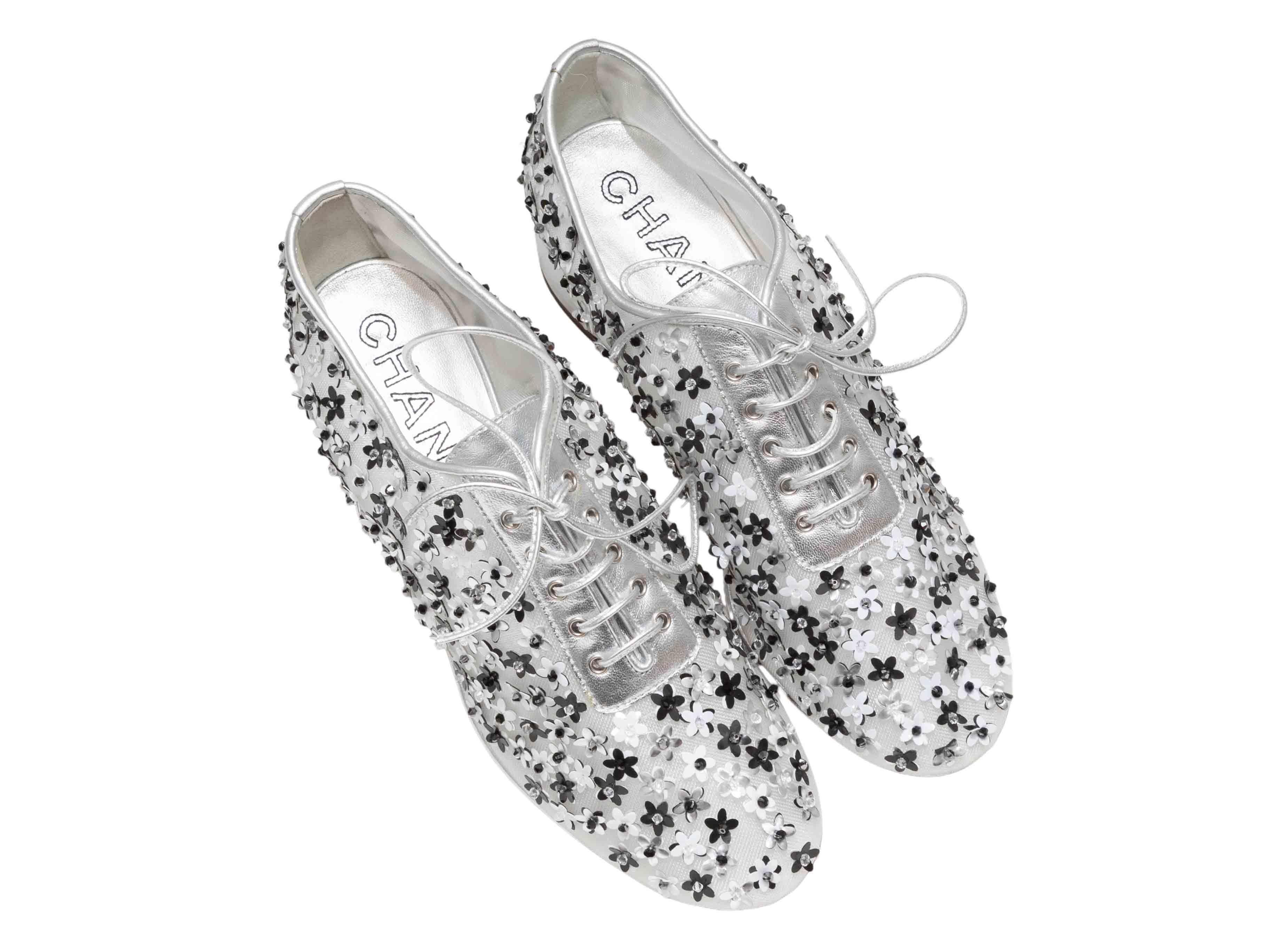 Chaussures à talons en cuir argenté et noir de Chanel. Appliques florales sur l'ensemble du corps. Talons hauts. Fermeture à lacets sur le dessus. Hauteur de talon de 1.5