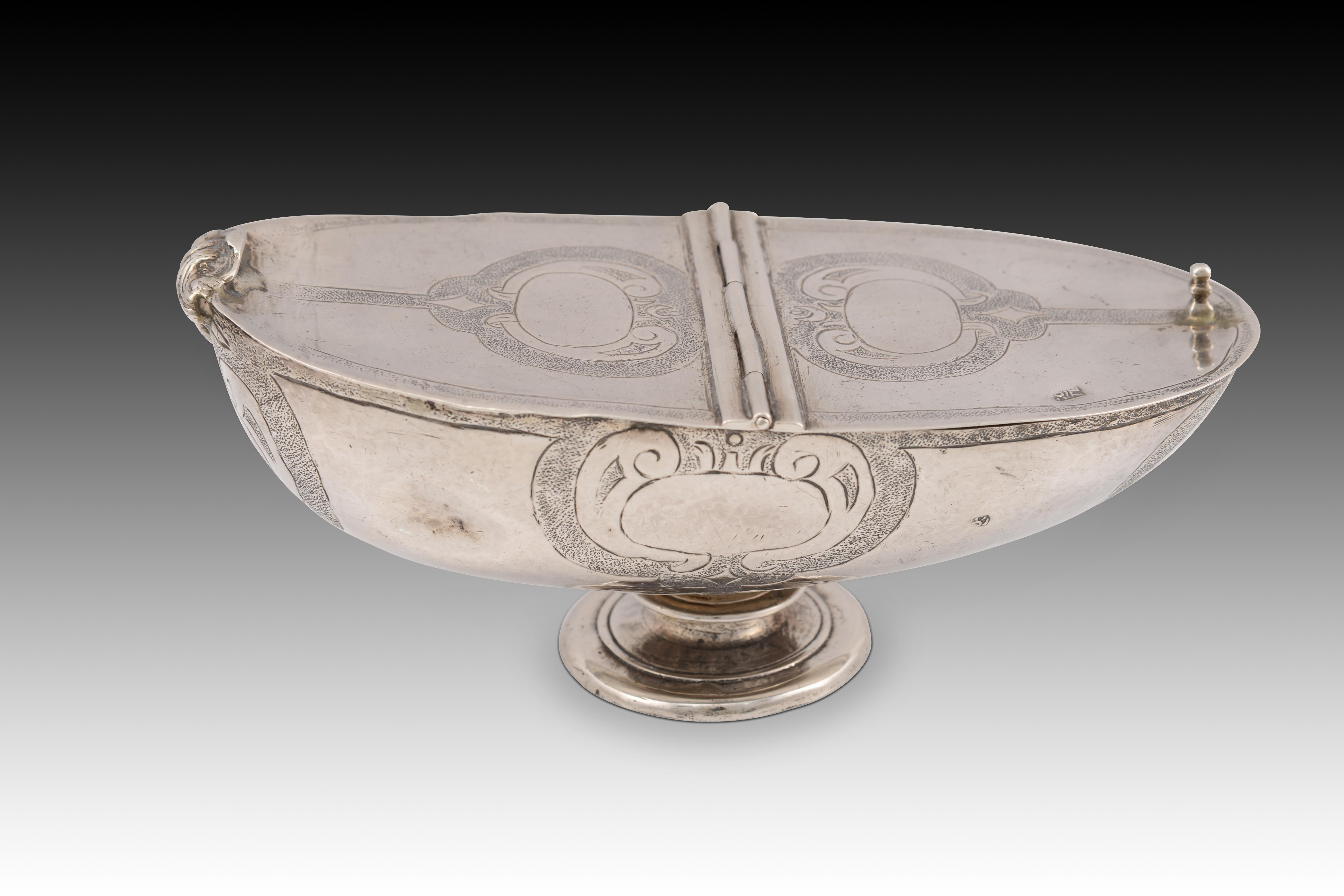 Silver ship. Spain, 17th century. 
Naveta formed by forging, with the foot and the ends of the lid obtained by mold casting. Shaped like a symmetrical boat, it stands on a low circular foot, with a discoidal base and a short shaft with a central