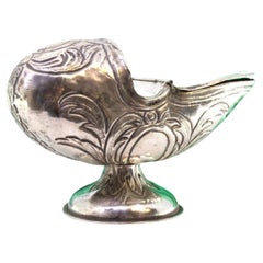 Silver boat w/ reliefs 
applications, resting on a base w/ a monogram plaque