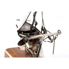 Silver boat with applications on a wooden base