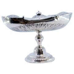 Silver boat with reliefs and applications, set on a round, engraved base