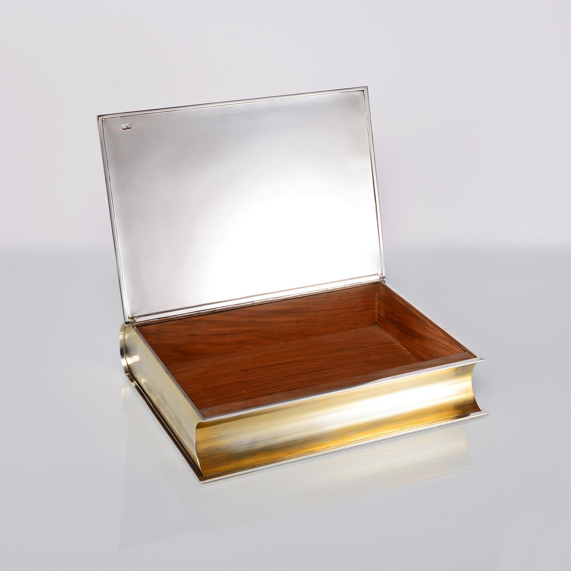 Large fine quality handmade wood-lined silver box with gilded sections, in the form of a traditional leather-bound book. The body is engraved to resemble the pages and the spine to resemble the traditional embossed mouldings of an antique leather