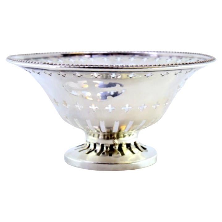 Silver bowl with pearly cutouts and friezes, set on a circular base