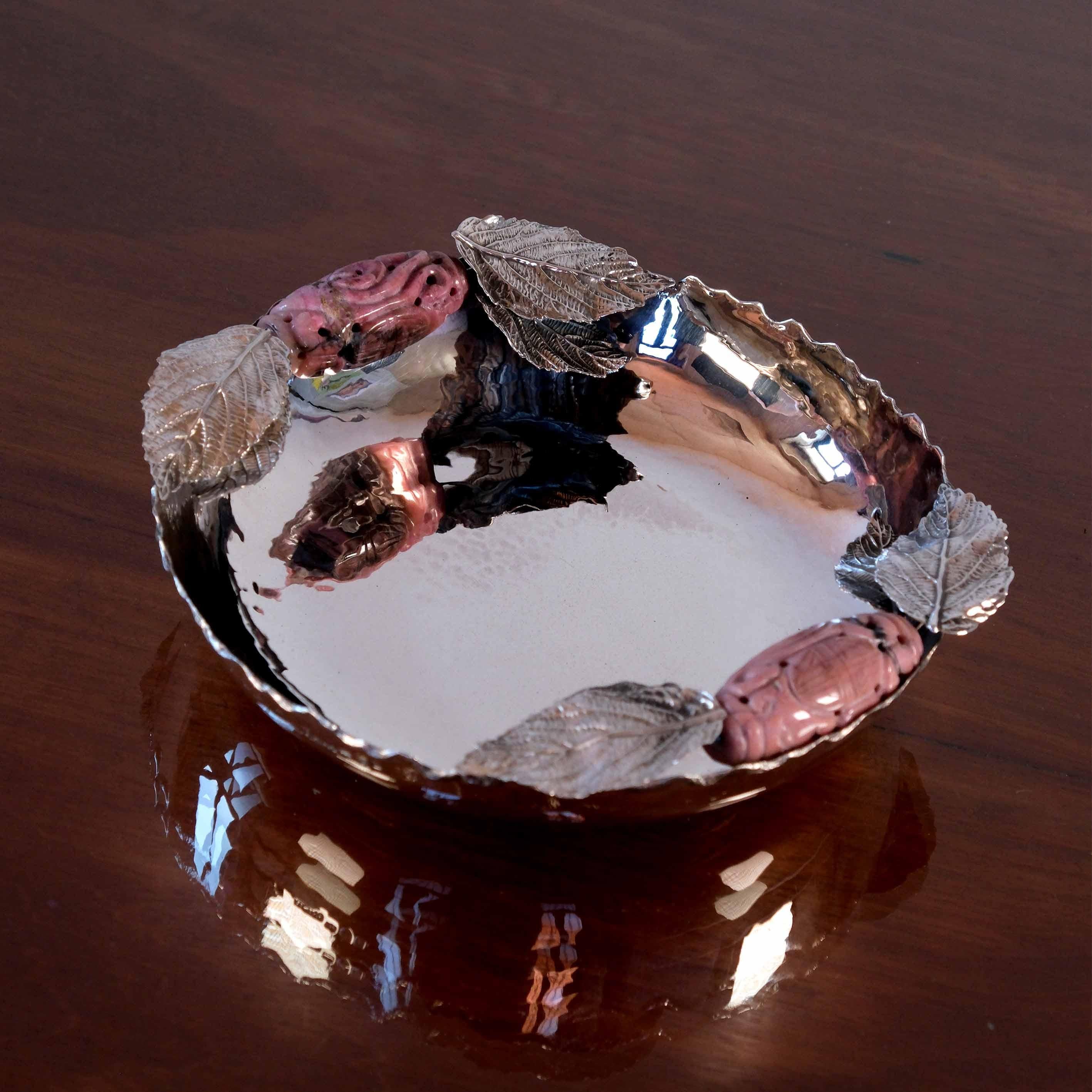 Cette pièce moderne contemporaine est composée d'un bol en argent sterling (925/1000) fabriqué à la main avec des feuilles et des pierres précieuses en rhodonite.

Cette pièce a été conçue et produite dans notre atelier de Porto, au